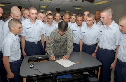 Leading by example, Brig. Gen. Darrell Jones, a former 37th Training Wing commander at Lackland Air Force Base, signs his Combined Federal Campaign form in front of some of the Air Force's upcoming Airmen currently assigned to Flights 559 and 560 of the 326th Training Squadron on Sept. 4, 2007. (USAF photo by Alan Boedeker)                                