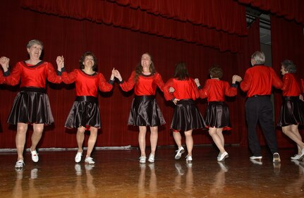 Retired Lt. Col. Linda McCullers, center, leads the Texas Thunder Cloggers in one of their dance routines during the International Folk Festival at Arnold Hall Aug. 25. 2007. This is the first International Folk Festival on Lackland AFB, Texas. (USAF photo by Alan Boedeker)                               