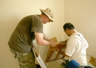 Staff Sgt. Brendan Wendt, left, and Elias Abdulahad, start the assembly of a kitchen cabinet. Both men work with the 37th Civil Engineer Squadron at Lackland AFB, Texas. This is the second build the civil engineering team has participated in. They dedicated their time and service to the build in honor of the late Dan Williamson, a structural engineer who regularly volunteered for Habitat for Humanity and organized the first CE team of Habitat builders. "Dan passed away a couple days after that build," said Charleen Byrd, 37th Civil Engineer Squadron and Habitat for Humanity volunteer. "It was the last day many folks saw him. ...We had so much fun that we decided to continue (his) tradition. We are going to put a together a team for each of the builds - summer, fall, winter and spring."