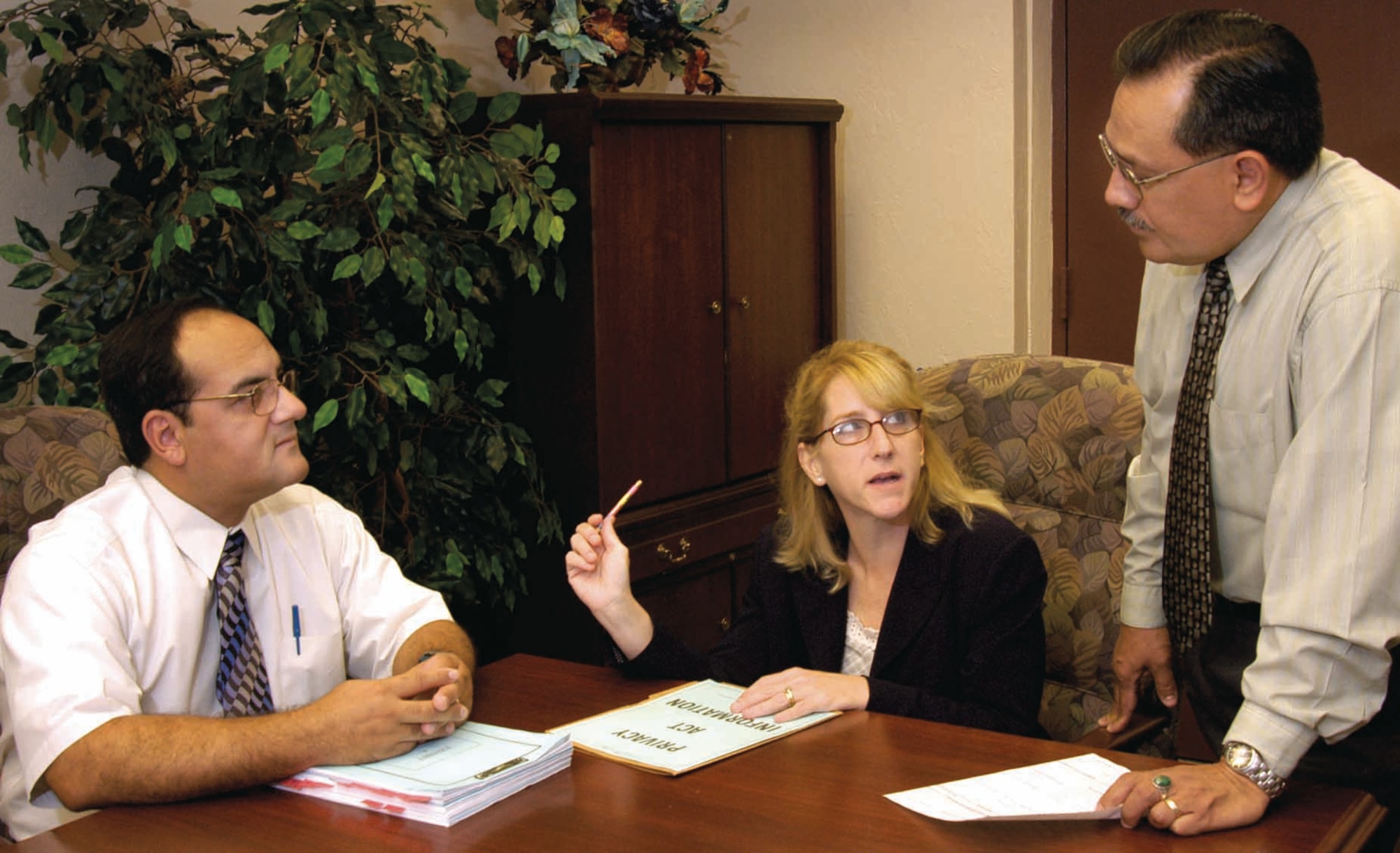 When a workplace dispute is handled by the Equal Employment Opportunity office, counselors like Raul Rodriguez, standing, may work with other organizations in the process. Department of Defense Investigations and Resolutions Division investigator Ray Cantu, left, comes to Tinker as needed, meeting with EEO personnel and others such as Kem Shively, a Civilian Personnel technical advisor. (Air Force photo by Margo Wright)