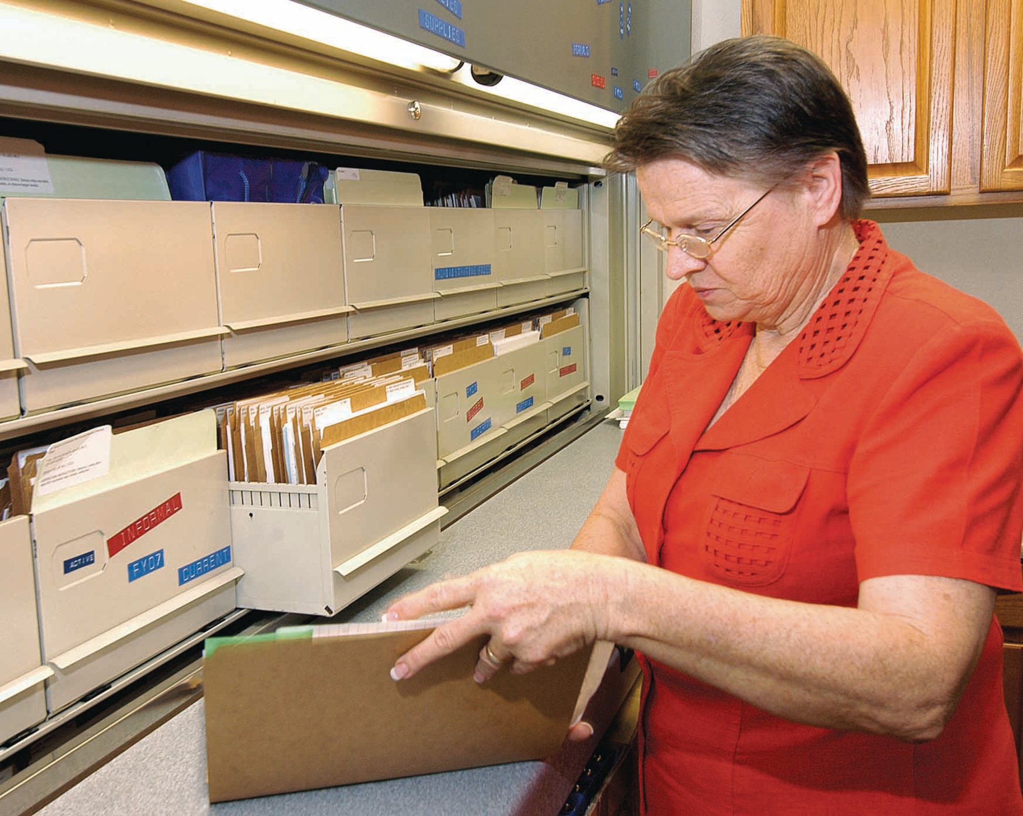 Carol Pope, an equal employment administrative assistant, manages a massive file system for ongoing and closed cases.  One case may yield files five inches thick with documents. (Air Force photo by Margo Wright)