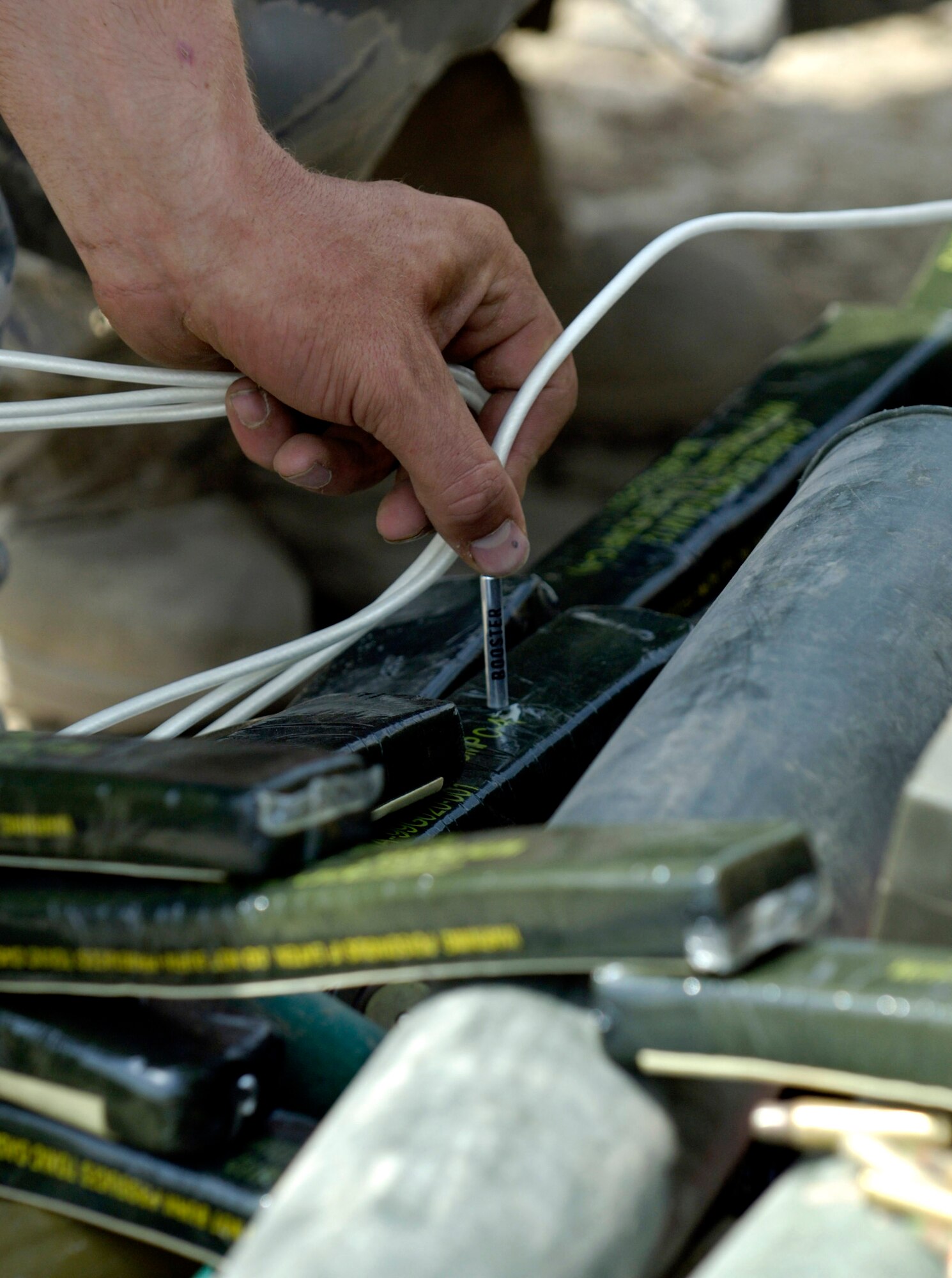 An Air Force explosive ordnance disposal specialist from Forward Operating Base Mehtar Lam, Afghanistan, readies ammunition for a controlled detonation Sept. 1. Nearly 900 pounds of small arms ammunition, rocket-propelled grenades and mortars were turned in by provincial citizens. (U.S. Air Force photo/Master Sgt. Jim Varhegyi) 
