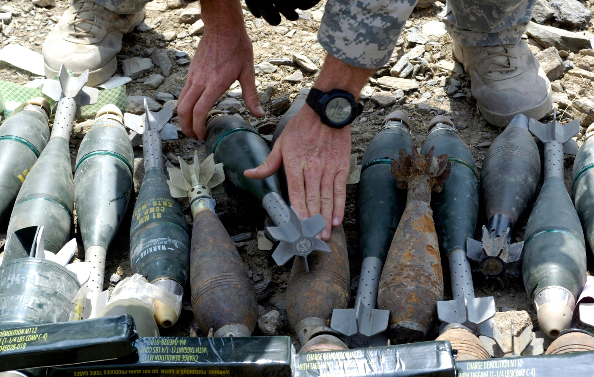 An Air Force explosive ordnance disposal specialist from Forward Operating Base Mehtar Lam, Afghanistan, readies ammunition for a controlled detonation Sept. 1. Nearly 900 pounds of small arms ammunition, rocket-propelled grenades and mortars were turned in by provincial citizens. (U.S. Air Force photo/Master Sgt. Jim Varhegyi) 
