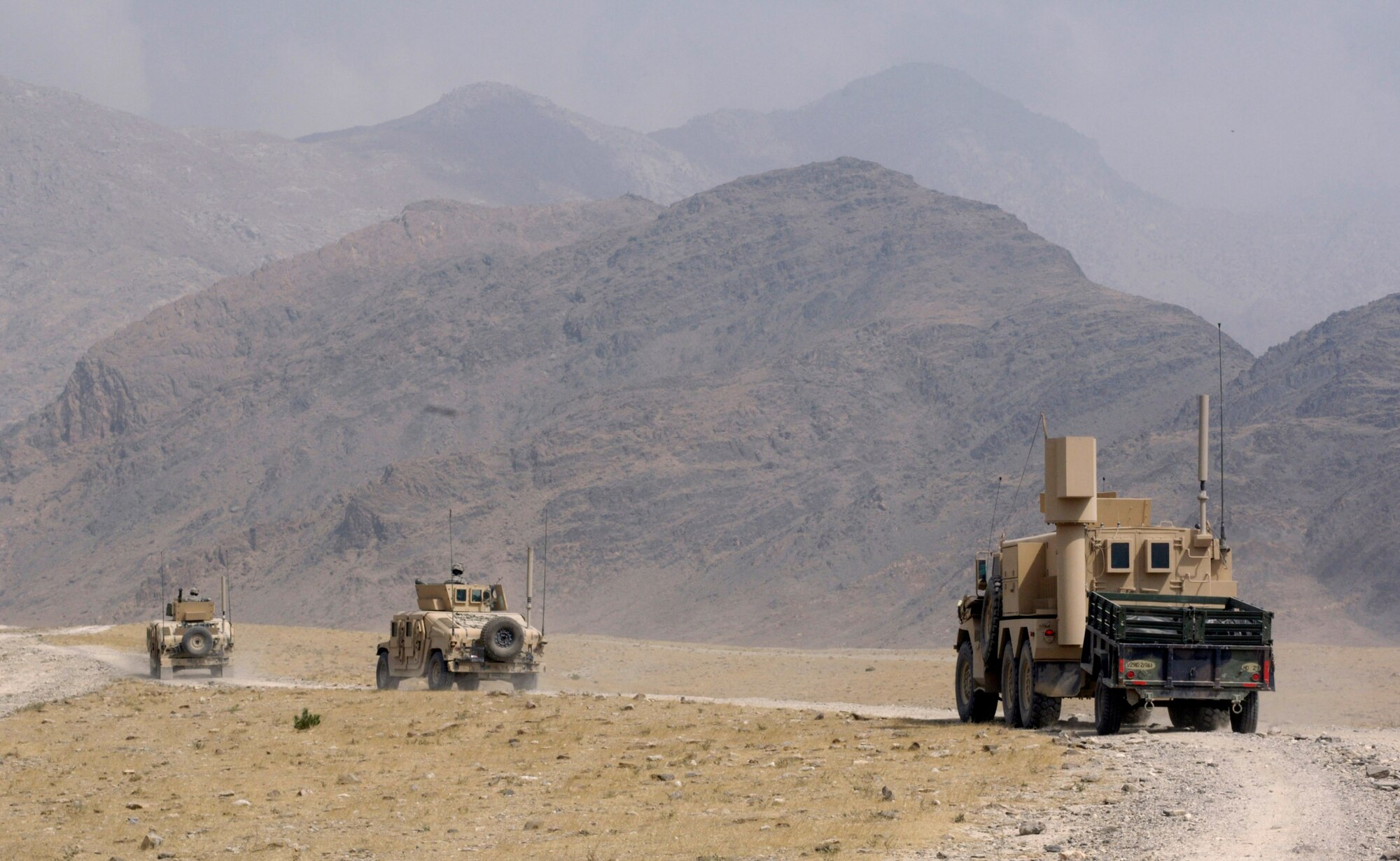 Air Force explosive ordnance disposal specialists from Forward Operating Base Mehtar Lam, Afghanistan, travel in Humvees to prepare a site for a controlled detonation Sept. 1. Nearly 900 pounds of small arms ammunition, rocket-propelled grenades and mortars were turned in by provincial citizens. (U.S. Air Force photo/Master Sgt. Jim Varhegyi) 