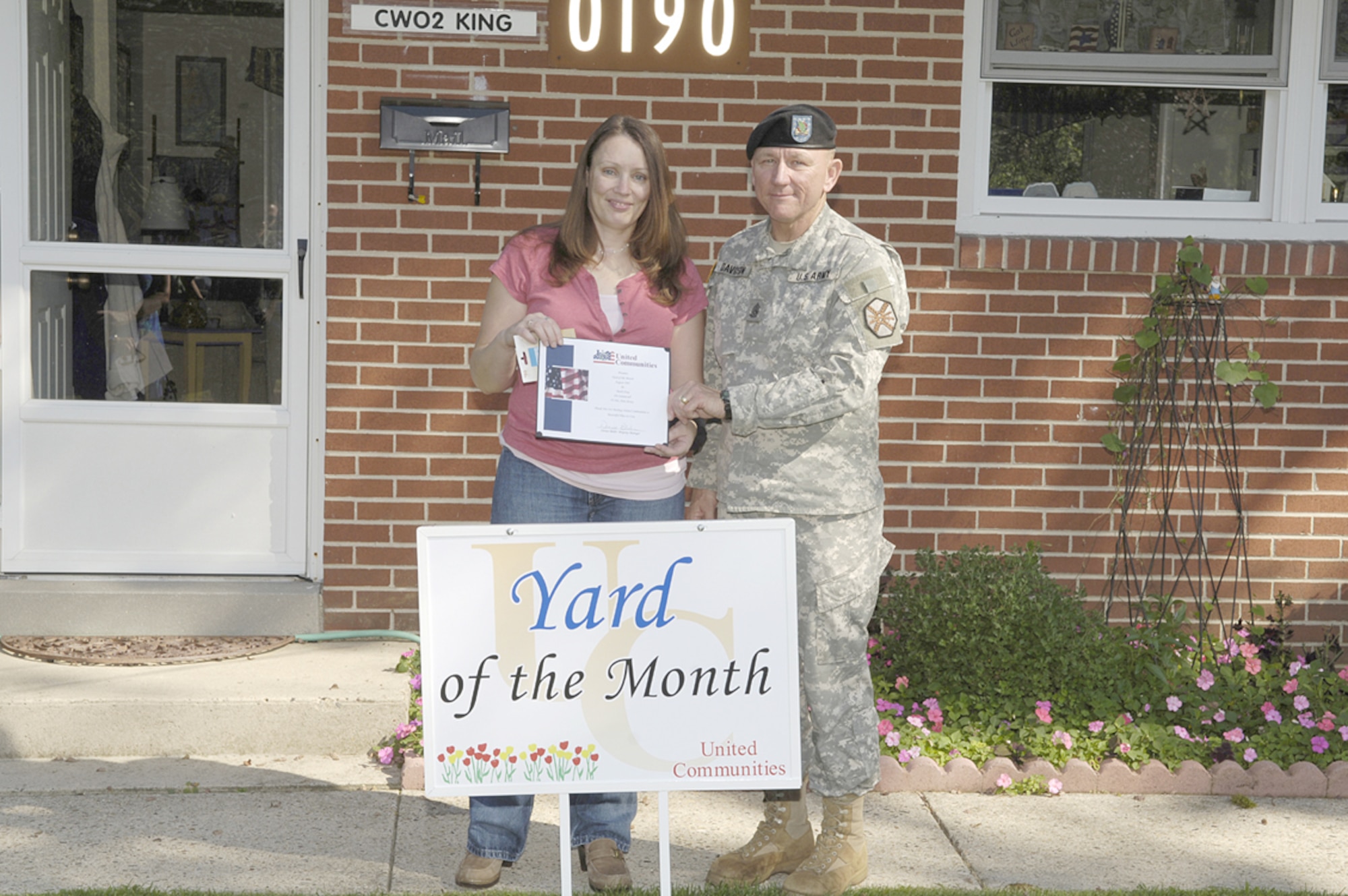 The wife of Chief Warrant Officer Mark King accepts Yard of the Month from Command Sgt. Maj. Ken Davidson, Fort Dix. Each month during the summer, one Yard of the Month and one Honorary Yard of the Month are selected in the McGuire and Fort Dix housing areas.
