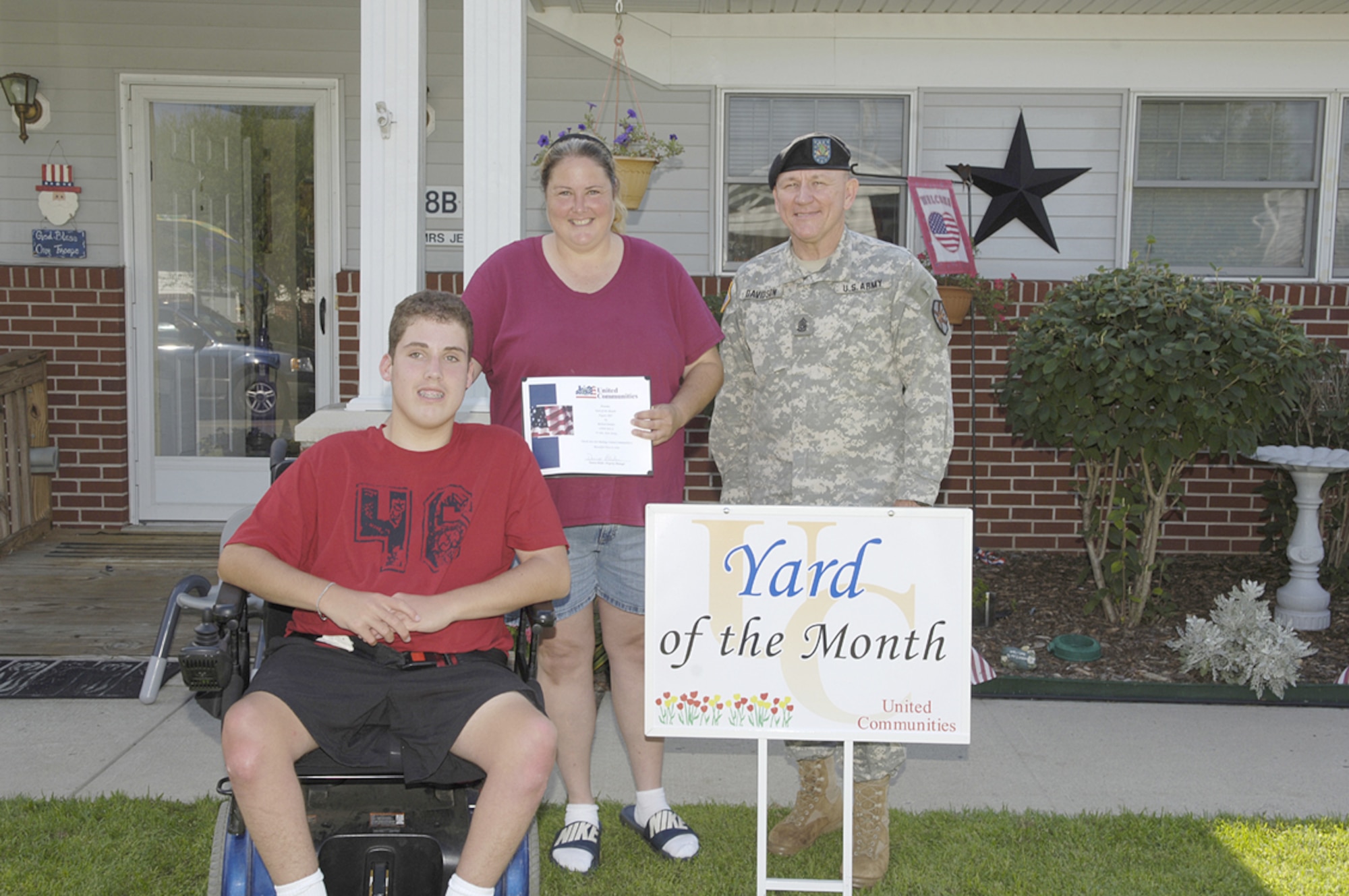 The family of Staff Sgt. Richard Jenkins accepts Yard of the Month from Command Sgt. Maj. Ken Davidson, Fort Dix. Each month during the summer, one Yard of the Month and one Honorary Yard of the Month are selected in the McGuire and Fort Dix housing areas.