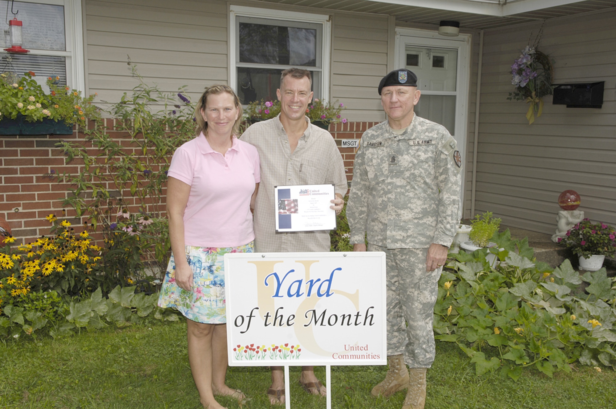 Master Sgt. Michael Elson and wife accept Yard of the Month from Command Sgt. Maj. Ken Davidson, Fort Dix. Each month during the summer, one Yard of the Month and one Honorary Yard of the Month are selected in the McGuire and Fort Dix housing areas.