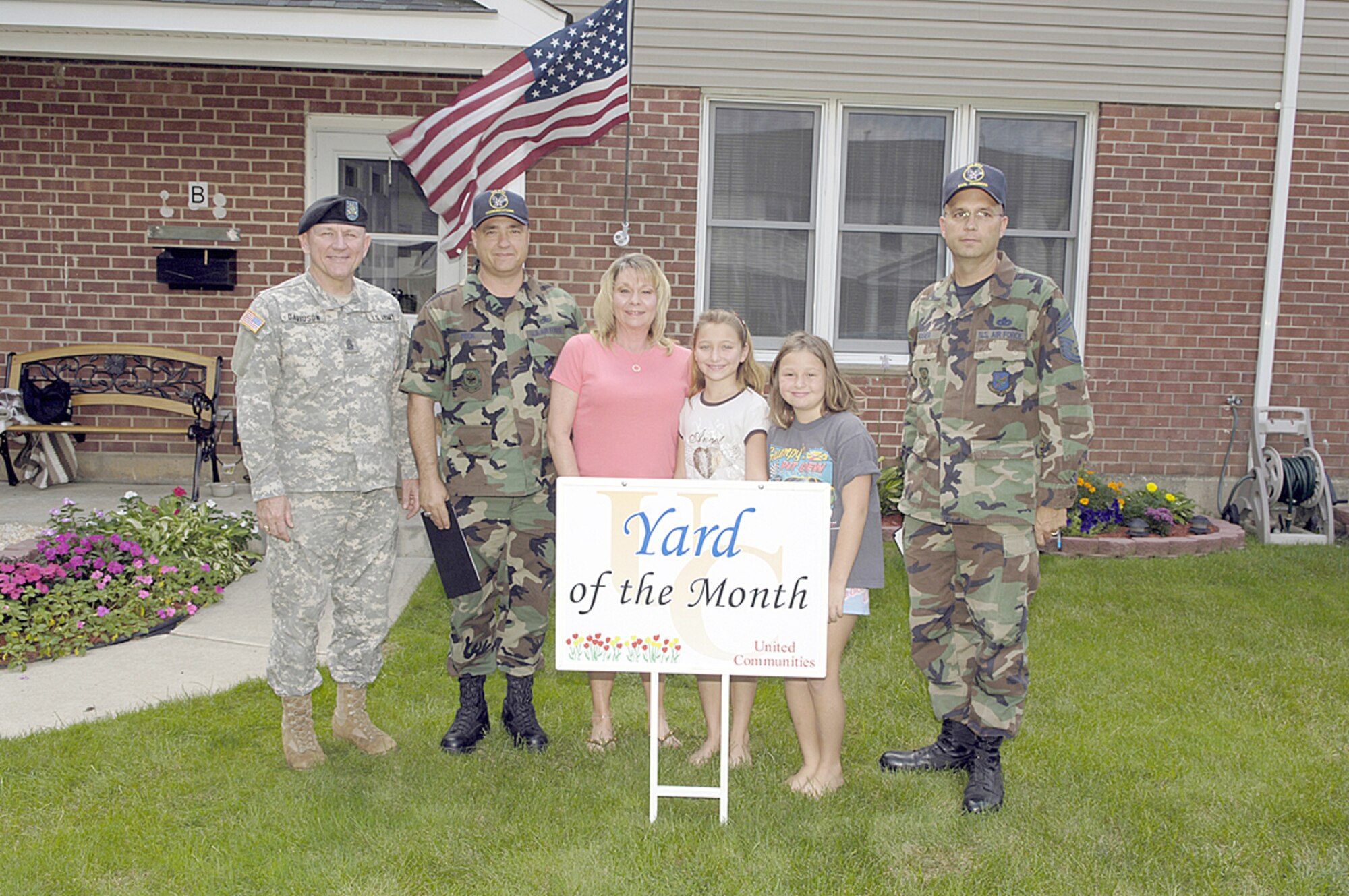 Master Sgt. Thomas Feck and family accept Yard of the Month from Command Sgt. Maj. Ken Davidson, Fort Dix, and Chief Master Sgt. Brian Mosier, 30th Civil Engineer Squadron. Each month during the summer, one Yard of the Month and one Honorary Yard of the Month are selected in the McGuire and Fort Dix housing areas.