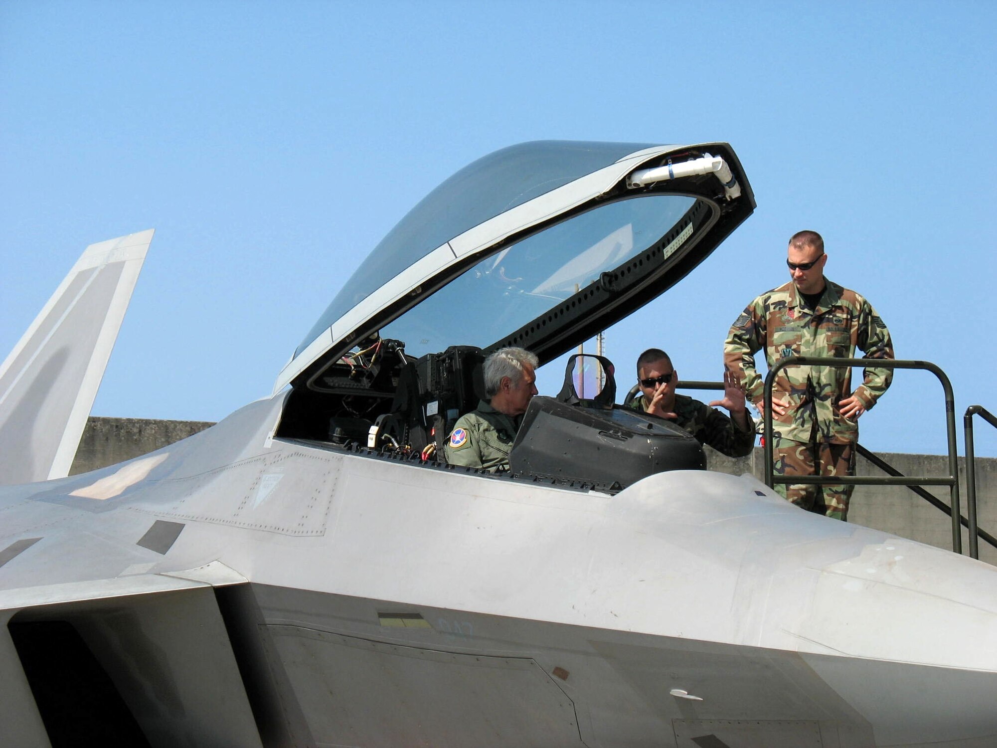 Airmen from the 27th Fighter Squadron at Langley Air Force Base, Va., speak with Alex Trebek, host of the TV game show "Jeopardy!," as he sits in the cockpit of an F-22 Raptor at Kadena Air Base, Japan, in March. Mr. Trebek and his crew were on a USO tour and taped video clues at various base locations in honor of the Air Force's 60th anniversary this year. Other aircraft featured in the clues included the F-15 Eagle, KC-135 Stratotanker and the HH-60 Pave Hawk. (U.S. Air Force photo)
