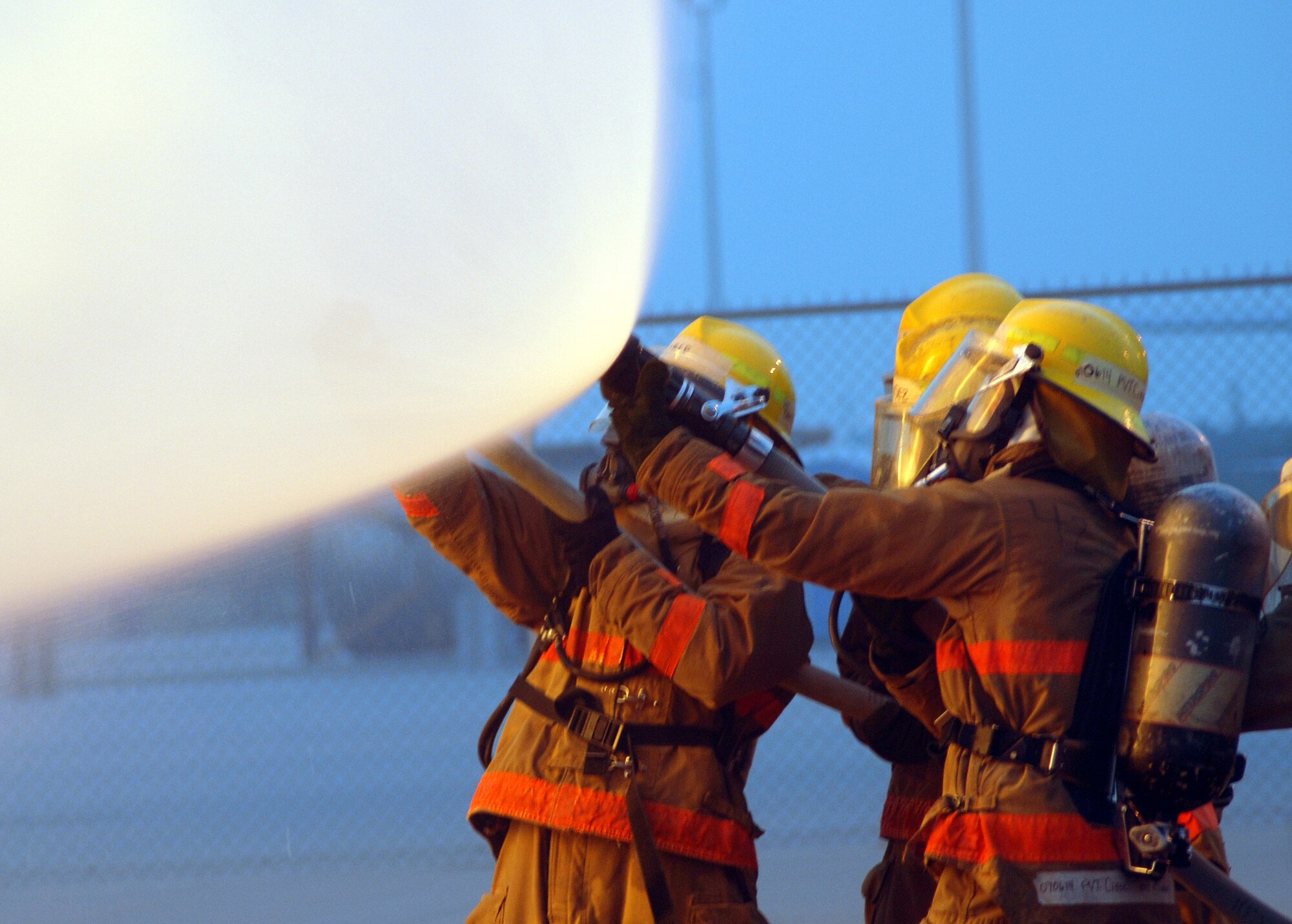 Firefighting students at the Louis F. Garland Department of Defense Fire Academy work as a team to direct their hose toward a fire during training Aug. 16. (U.S. Air Force photo by Airman 1st Class Kamaile Chan)