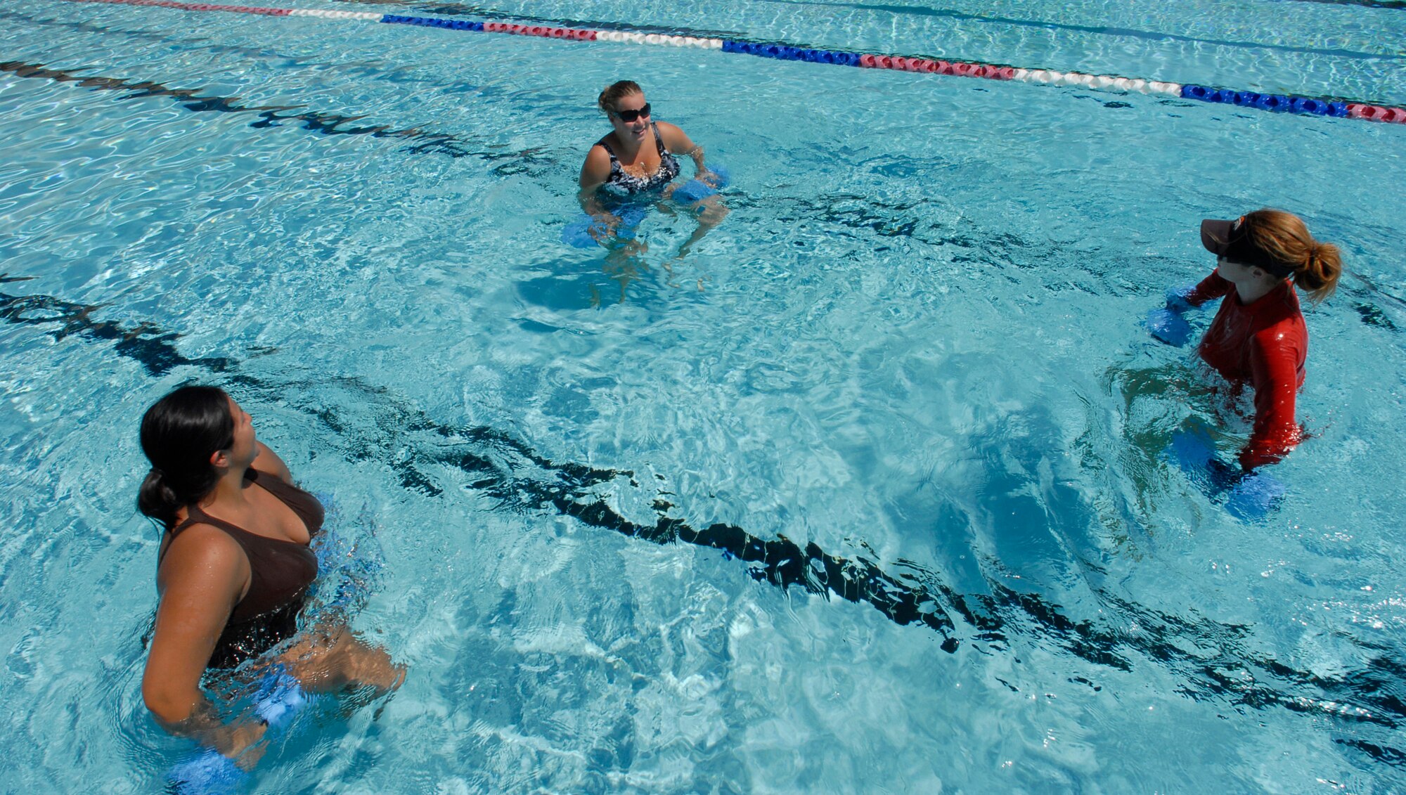 Staff Sgt . Mel issa Tennant, left, and Senior Airman Carly Smith, center, 56th Equipment Maintenance Squadron munitions specialists, use weights to augment
their exercise Wednesday while receiving instruction from Erika Brayton, 56th Services Squadron aerobic instructor at the Silver Wings Pool. As compared to exercises done on land, water aerobic exercises can be more effective in burning calories and can burn as much as 700 calories per hour. (Photo by Senior Airman Christopher Hummel)