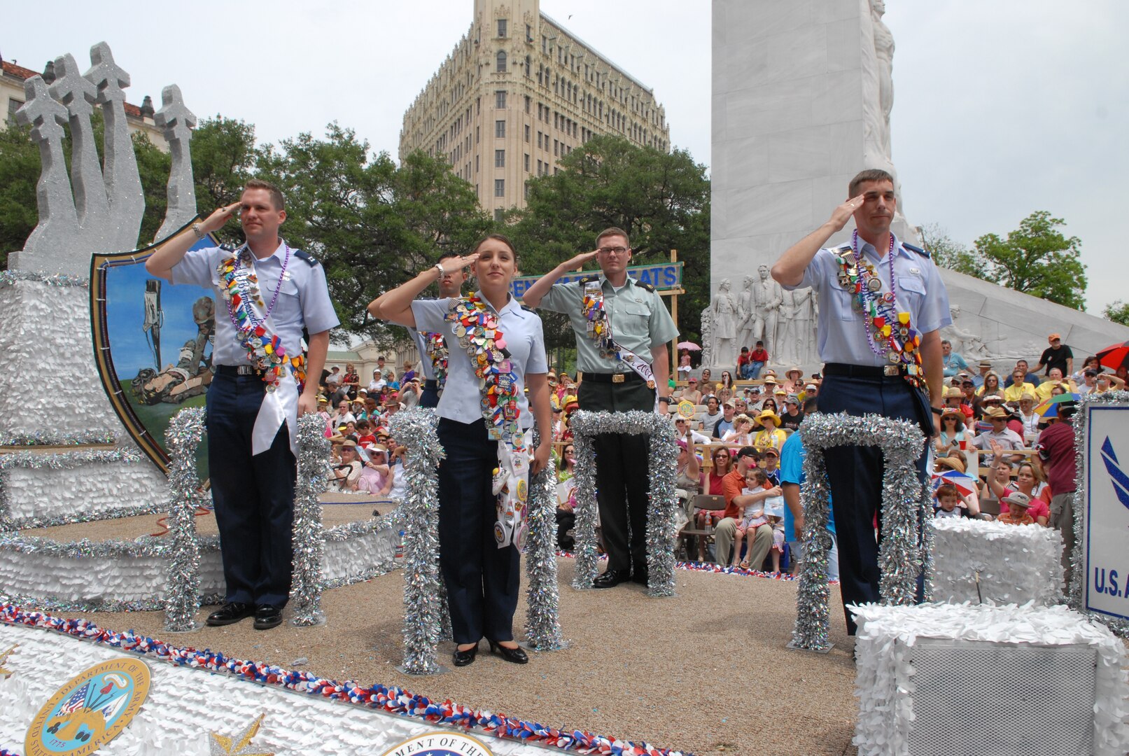 First Lt. Jennifer Ferrer (left center) joins other military ambassadors in saluting the official party from a float at the 2007 Fiesta celebration in downtown San Antonio. (U.S. Air Force photo by Rich McFadden)