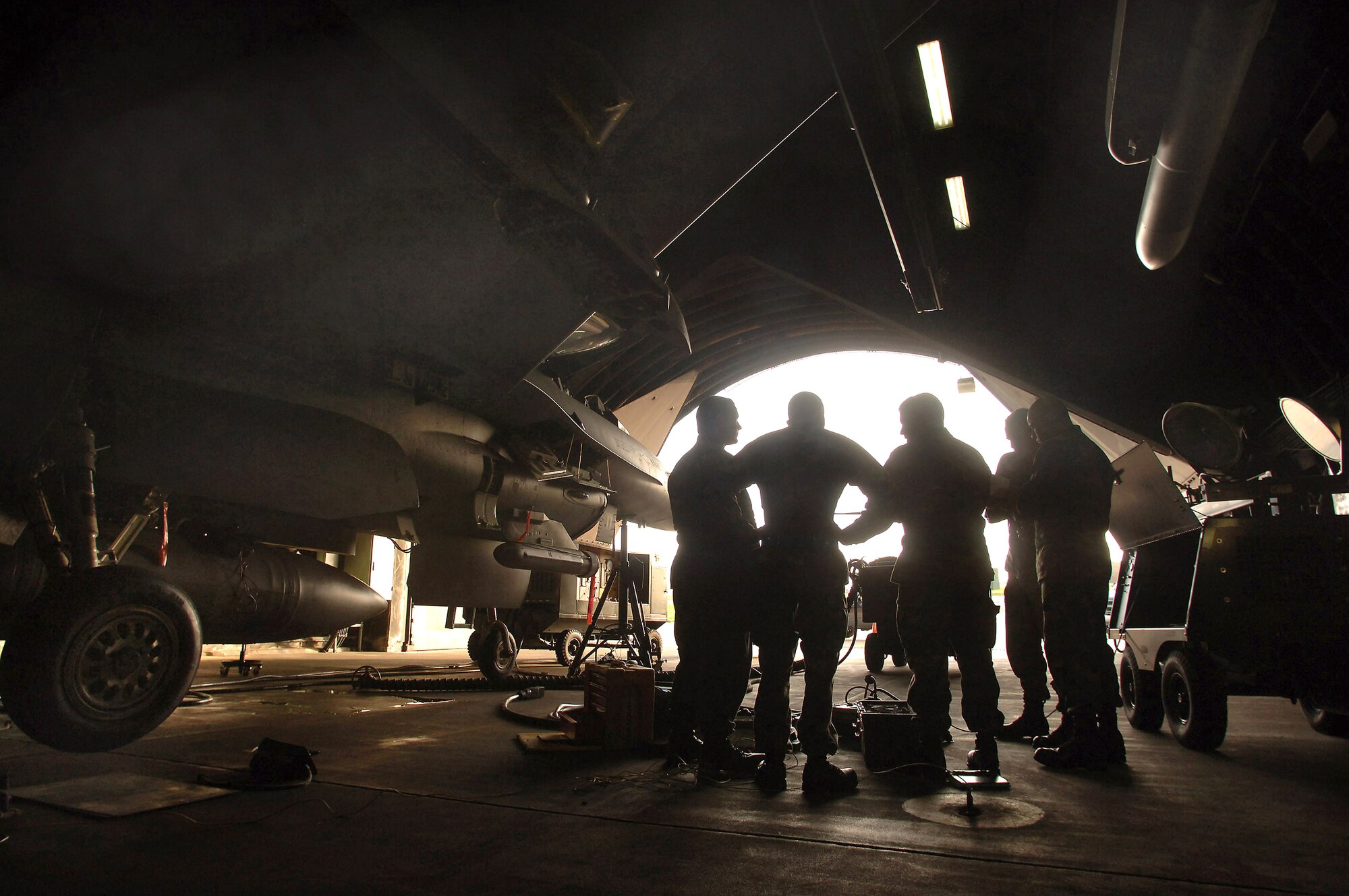 Avionics technicians assigned to the 23rd Aircraft Maintenance Unit at Spangdahlem Air Base, Germany, discuss repairs on an F-16 Fighting Falcon that experienced an in-flight malfunction Aug. 29. Avionics specialists must be familiar with nearly 40 separate avionics systems that are built into the multi-role fighter.  (U.S. Air Force photo/Master Sgt. Scott Wagers)