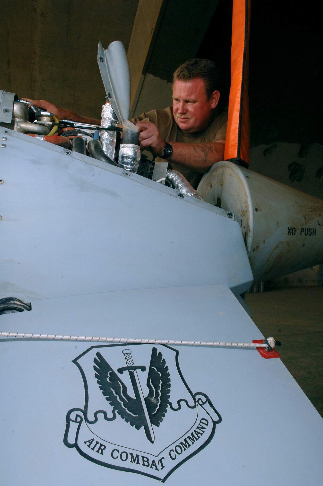 Russell Gordy works on a cooling fan on an MQ-1 Predator unmanned aerial vehicle after it flew over Balad Air Base, Iraq. The Predator provides armed reconnaissance, airborne surveillance and target acquisition for Operation Enduring and Iraqi Freedom. Mr. Gordy is an avionics mechanic. (Air Force photo/Airman 1st Class Jonathan Steffen) 
