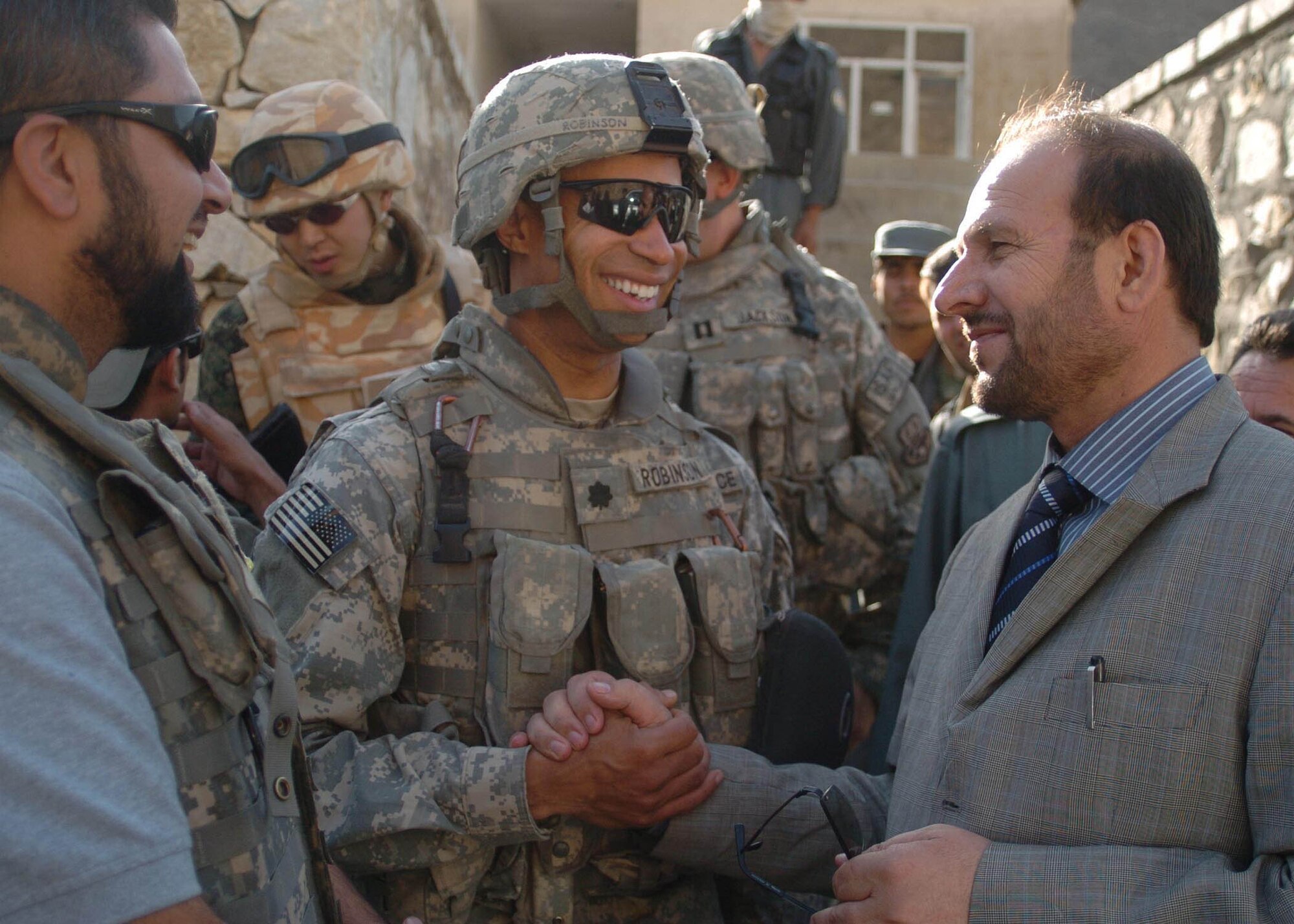Air Force Lt. Col. Bobby Robinson (center), Bagram Provincial Reconstruction Team commander, and Parwan Province Deputy Gov. Abdul Basir Salangi (right), shake hands after surveying a possible construction sight for Parwan’s newest district center Sept. 5 in Salang District, Afghanistan. (U.S. Air Force photo by Senior Airman Dilia DeGrego)