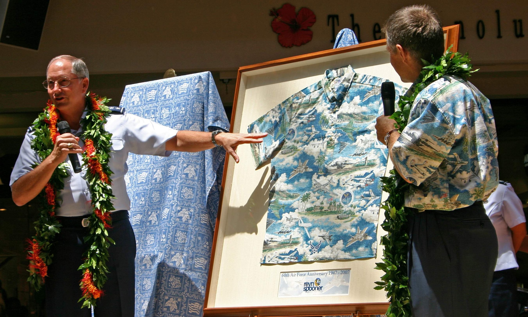 Tim McCullough (right) presents the Air Force 60th Anniversary Aloha shirt to Lt. Gen. Loyd S. "Chip" Utterback Sept. 9 at Centerstage in Ala Moana Center in Hawaii. Mr. McCullough is from the Reyn Spooner, and General Utterback is the 13th Air Force commander.  The shirt was designed by Reyn's to highlight the Air Force's 60th birthday and was one of the first events of Air Force Week Honolulu, taking place Sept. 7 through 15. (U.S. Air Force photo/Tech. Sgt. Chris Vadnais) 
