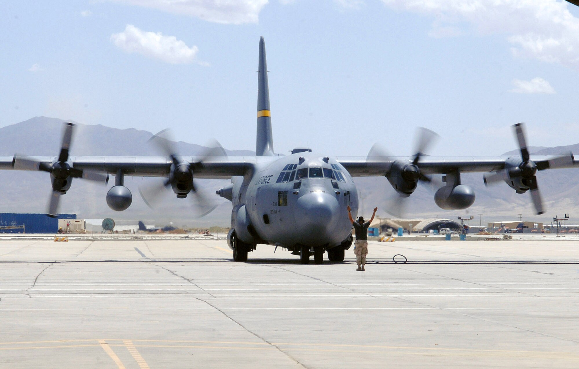 A C-130 Hercules crew chief from the 455th Expeditionary Maintenance Group marshals a C-130 onto its parking spot on the flightline at Bagram Air Base, Afghanistan. Coalition C-130s as well as C-17 Globemaster IIIs flew 130 sorties delivering approximately 580 tons of cargo and nearly 3,000 passengers around Southwest Asia Sept. 8. (U.S. Air Force photo/Staff Sgt. Craig Seals) 
