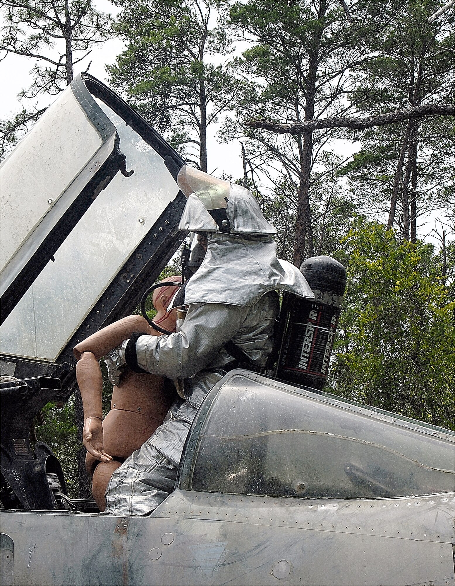 A 442nd Civil Engineer Squadron firefighter from Whiteman Air Force Base, Mo., "rescues" a crewmember from a "crashed " aircraft at the Silver Flag exercise area at Tyndall AFB, Fla..
Detachment 1, 823rd RED HORSE (Rapid Engineer Deployable Heavy Operational Repair Squadron Engineers) Squadron at Tyndall hosts the exercise and used a decommissioned F-4 Phantom fighter placed in the woods on the Silver Flag site to provide a more realistic scenario of an aircraft crash as a training aid. (US Air Force photo/Master Sgt. Bill Huntington)