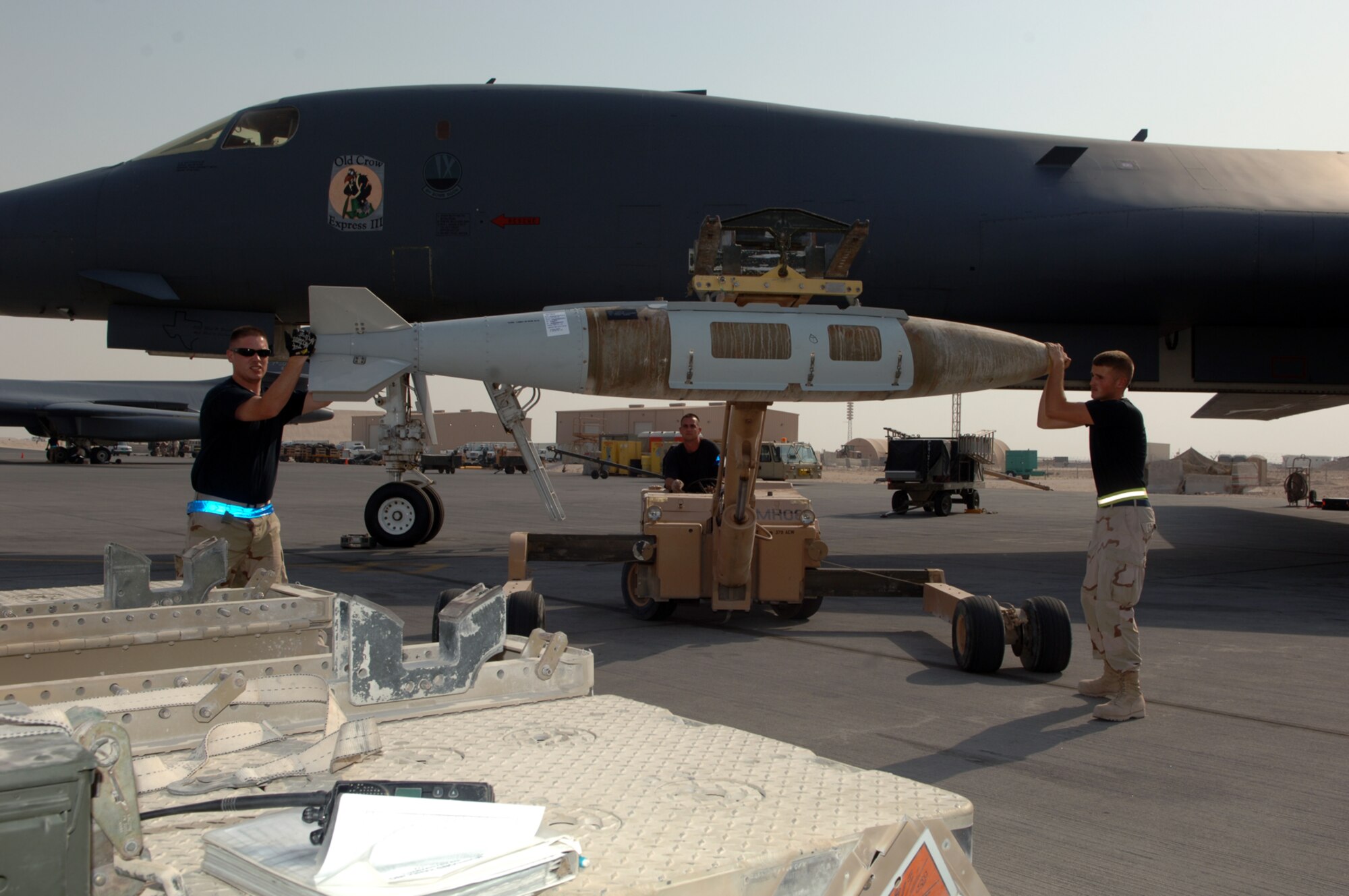(From left) Senior Airman Jeremy Ridings, Master Sgt. Jerry Shelton, both with the 379th Expeditionary Aircraft Maintenance Squadron, and Airman 1st Class James Deason, with the 379th Expeditionary Maintenance Squadron, prepare to load a guided bomb unit-31 onto a B-1B Lancer, preparing it for a mission. The weapons flight has loaded more than 400 tons of munitions onto B-1s since July 24. (U.S. Air Force photo by Master Sgt. Ken Stephens)