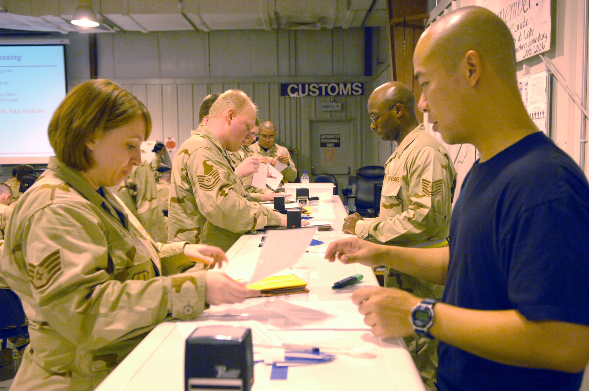 Tech. Sgt. David Fryer, 379th Expeditionary Services Squadron (right) , briefs incoming Airman on inprocessing procedures for the 379th Air Expeditionary Wing.  (U.S. Air Force photo by Master Sgt. Ken Stephens)