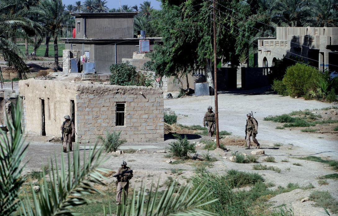 Marines with Company K, 3rd Battalion, 3rd Marines Regiment with Regimental Combat Team 6, stationed at Camp Fallujah, patrol through a small village north of Karmah, Iraq, Sept. 10. Co. K started operations in the previously untouched territories that are known for insurgent activities and hope to push the insurgents out of the area or trap them in to be captured.