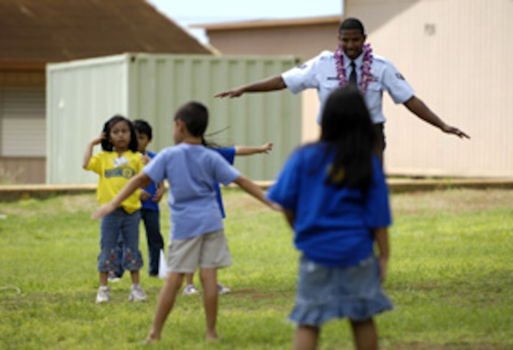 WAIPAHU, Hawaii -- Senior Airman Andrew William plays with children from August Ahrens Elementary School Sept. 10 during Air Force Week Honolulu. Eight hundred Airmen from Hickam Air Force Base spent their day at 80 local schools on the island of Oahu reading, playing and educating children about the Air Force. Airman William is from the 15th Airlift Wing Civil Engineer Squadron. (U.S. Air Force photo/Tech. Sgt. Shane A. Cuomo)