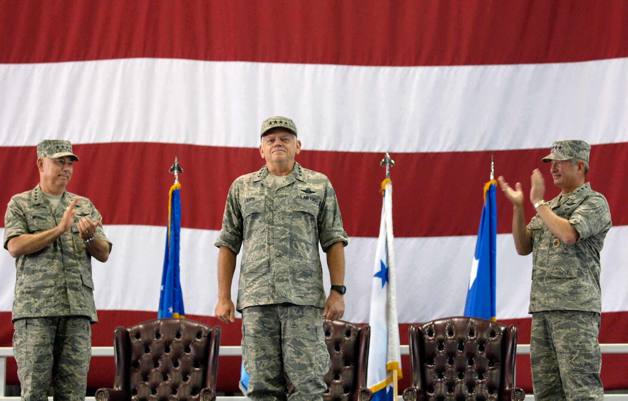 Gen. Arthur J. Lichte (center) is applauded by Air Force Chief of Staff General T. Michael Moseley (left) and Gen. Duncan J. McNabb, as he assumes command of Air Mobility Command Sept. 7 at Scott Air Force Base, Ill. (U.S. Air Force photo/Staff Sgt. Tony Tolley)