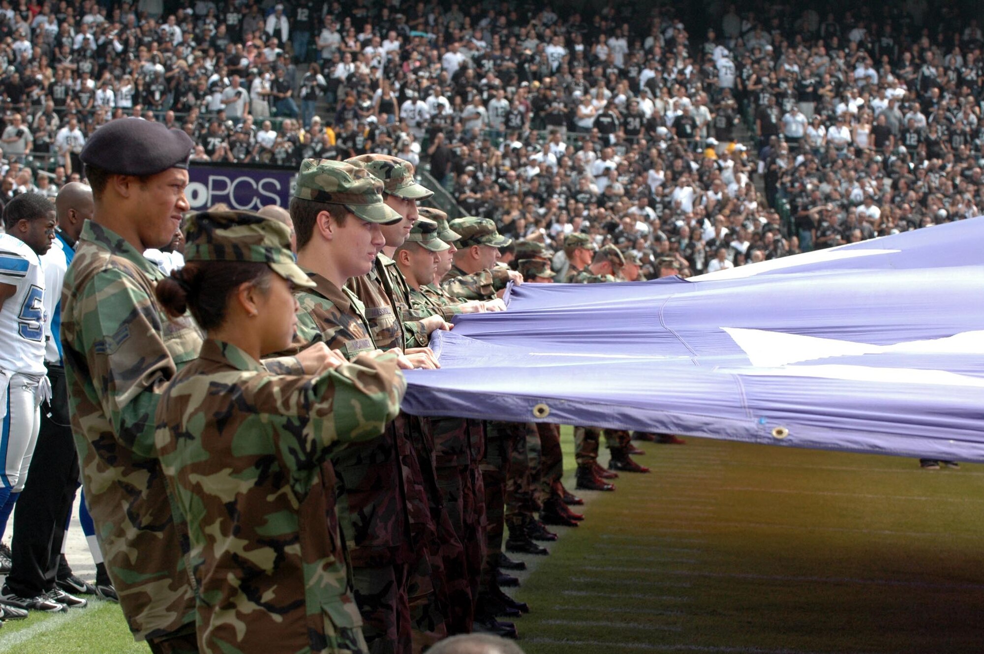 Travis Airmen hold the flag Sept. 9 prior to the Oakland Raiders' season-opening game against the Detroit Lions at McAfee Coliseum, Oakland, Calif. Afterward, the Airmen were invited to watch as the Detroit Lions defeated the Oakland Raiders, 36-21. (U.S. Air Force photo/Tech. Sgt. Donald Osborn)