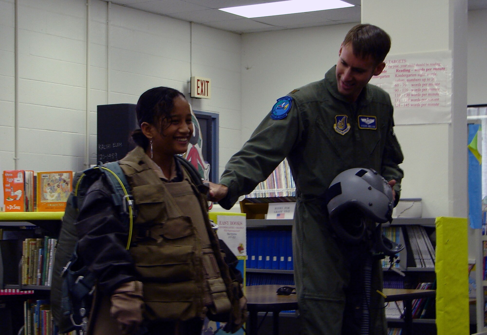 Aruko Rosokow, a fifth grade student at Kalihi Elementary School and Maj. Steve Snelson, aide de camp to the commander of Pacific Air Forces demonstrate wearing flight support equipment as part of Airmen in Education Day during Air Force Week Honolulu Monday. (USAF photo by Capt. Alllison Farabaugh)