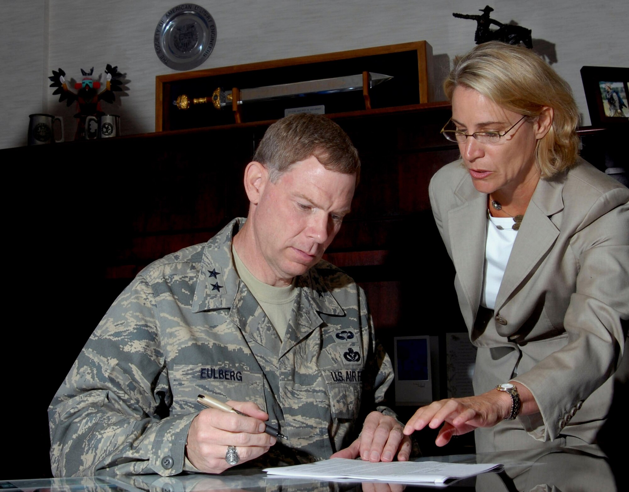 Maj. Gen. Del Eulberg signs the lease for his future home at Bolling Air Force Base, D.C., with help from Leslie Catlin. General Eulberg is the Air Force civil engineer at Headquarters Air Force in Washington, D.C. Ms. Catlin is the Pinnacle Operations director. Pinnacle is one of the management companies working with the Air Force to providing better housing to its members. (U.S. Air Force photo/Tech. Sgt. Cohen A. Young) 

