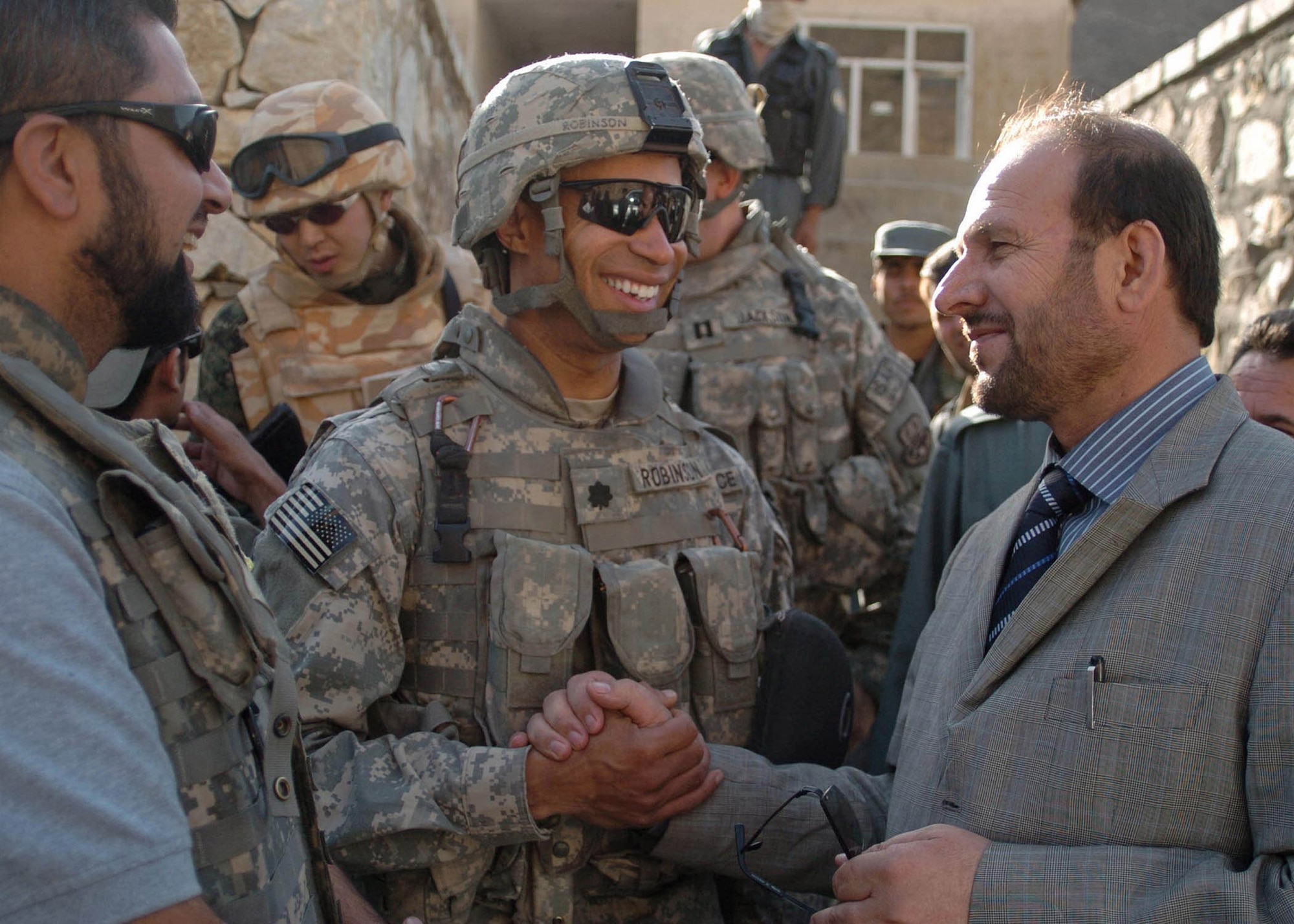 Lt. Col. Bobby Robinson (center), the Bagram Provincial Reconstruction Team commander, and Parwan Province Deputy Gov. Abdul Basir Salangi (right), shake hands after surveying a possible construction sight for Parwan?s newest district center Sept. 5 in Salang District, Afghanistan. (U.S. Air Force photo/Senior Airman Dilia DeGrego)