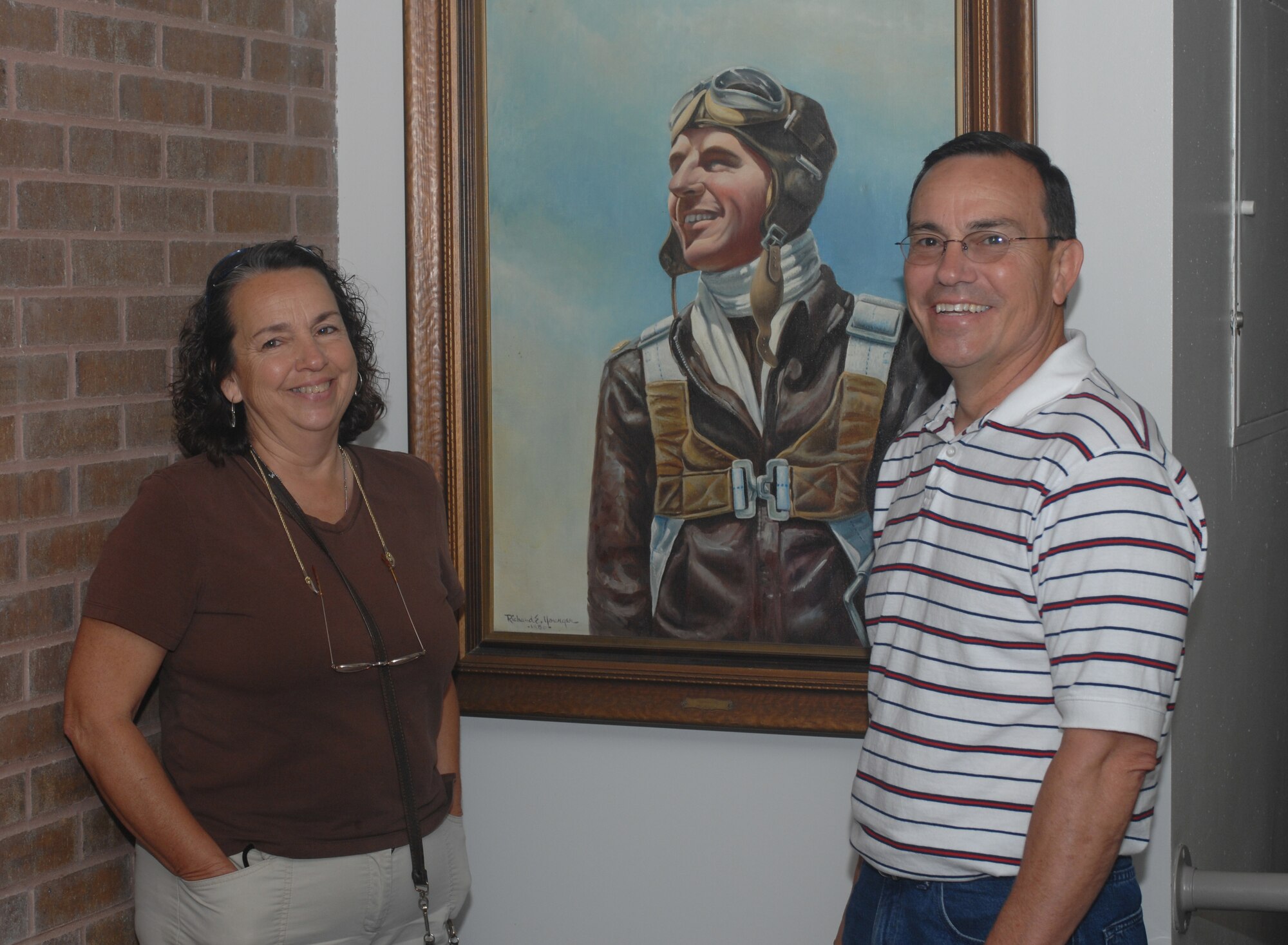 WHITEMAN AIR FORCE BASE, Mo. --  Cheryl Sisk and Glenn Berry pose next to a painting of their uncle, 2nd Lt. George Whiteman, at the 509th Bomb Wing headquarters building Sept 7. They also visited a B-2 Bomber and historical Oscar - 01 launch control facility during their tour. Sedalia Army Air Field became Whiteman Air Force Base Dec. 3, 1955 in honor of Lieutenant Whiteman. A native of Sedalia, the lieutenant was one of the first American Airmen killed in World War II when the Japanese attacked Pearl Harbor, Hawaii, Dec. 7, 1941. During the attack of Bellows Air Field, Oahu, Lieutenant Whiteman managed to reach his fighter aircraft. While attempting to take off, enemy fighters attacked his plane. Lieutenant Whiteman's P-40 crashed, fatally injuring him. By the time rescue teams reached the aircraft, the lieutenant had died. (U.S. Air Force Photo/Tech. Sgt. Samuel A. Park)