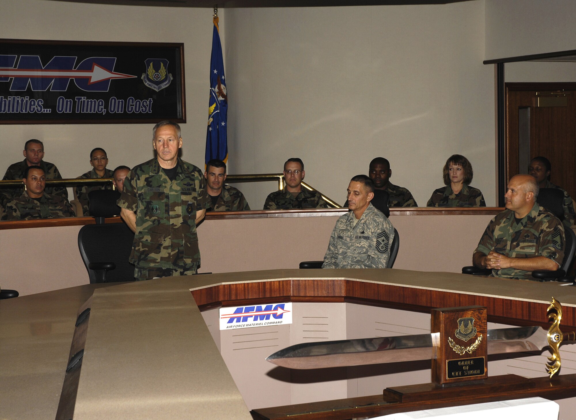 The commander of Air Force Materiel Command, Gen. Bruce Carlson (standing), addresses AFMC’s enlisted members after learning he was selected to receive the AFMC Order of the Sword. The Order of the Sword is the highest honor Air Force noncommissioned officers can give to an individual who has made significant contributions to the enlisted corps. (Air Force photo by Mike Libecap)