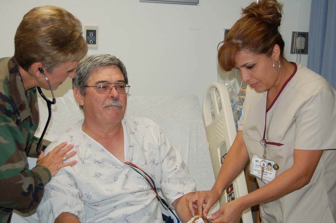 Major Janet Wickline, a Reservist with the 433rd Medical Squadron and Lilliana Castro, an R.N. at Southwest General Hospital check on the status of Ramon Ochoa, a patient in the hospital. Major Wickline is one of several Alamo Wing medical professionals serving on annual tour at Southwest General Hospital. (U.S. Air Force Photo/Amn. Viola Hernandez)