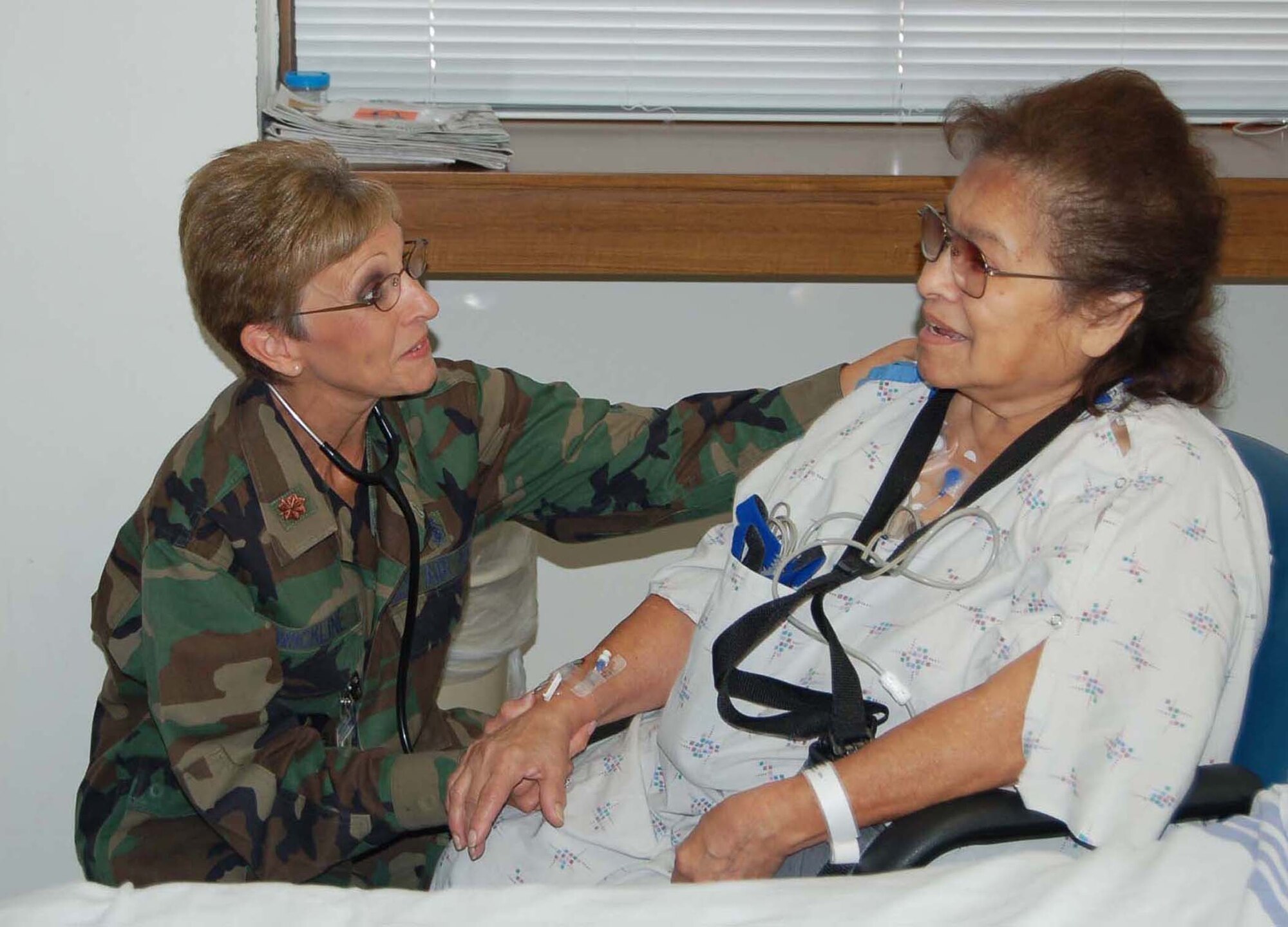 Maj. Janet Wickline, a nurse with the 433rd Medical Squadron speaks with Carmen Uriegas, a patient at Southwest General Hospital. Major Wickline is one of several Alamo Wing medical professionals serving on annual tour at Southwest General Hospital. (U.S. Air Force Photo/Amn. Viola Hernandez)