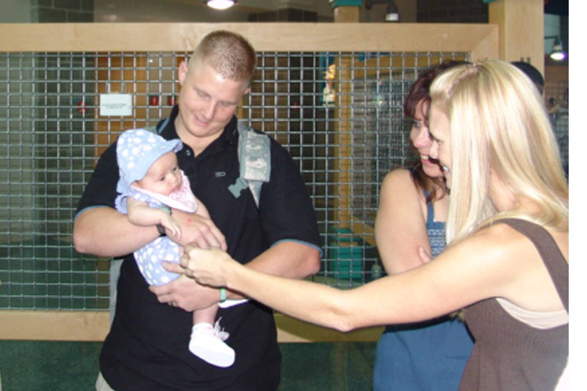 Senior Airman Travis Holcomb greets his daughter, Kayli, who was born while he was deployed.  Airman Holcomb was one of approximately forty 96th Security Forces Squadron personnel who returned from deployment this past weekend.                        