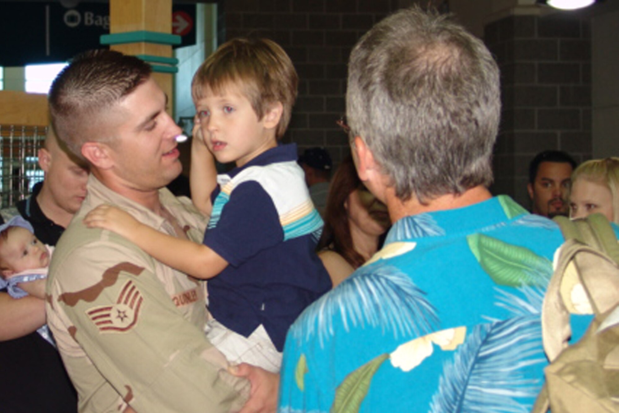 Staff Sgt. John Quinley holds his son, Gabriel, after he arrived at the Okaloosa Regional Airport.  Sergeant Quinley was one of approximately forty 96th Security Forces Squadron personnel who returned from deployment this past weekend.                               