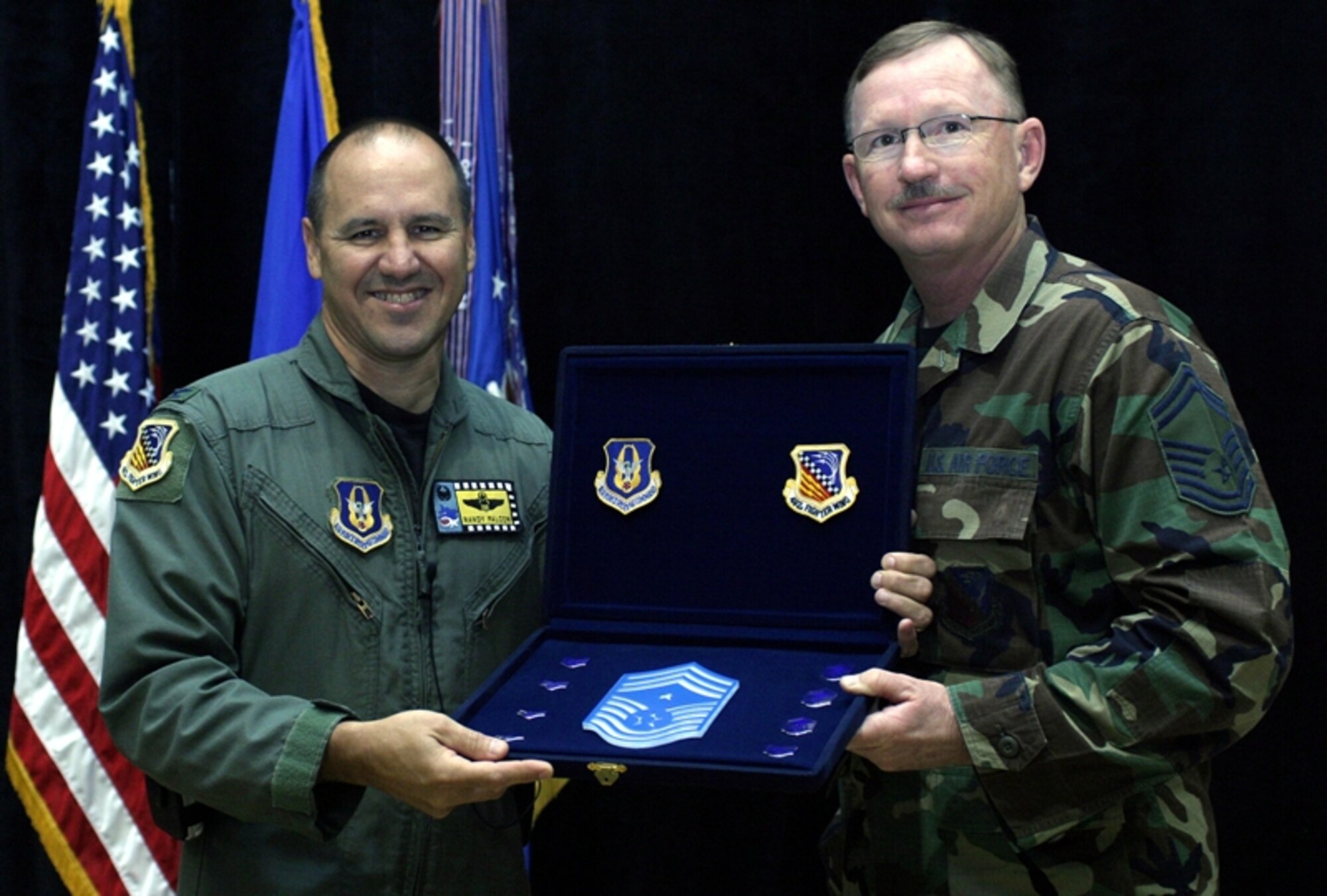 Col. Randall G. Falcon, 482nd Fighter Wing commander, presents a shadow box containing the enlisted rank structure to Senior Master Sgt. Clarence Tears after Sergeant Tears was named the new 482nd FW command chief master sergeant during September’s wing commander’s call.

Sergeant Tears previously served as the 482nd Civil Engineer Squadron engineering superintendent, and will replace Chief Master Sgt. Charles Clunie who served as command chief for two-and-a-half years. Chief Clunie is moving on to a position with the 482nd Fighter Wing’s Newcomer’s Flight where he will ensure top notch newcomer in-processing. (U.S. Air Force photo/Tech. Sgt. Paul Dean)