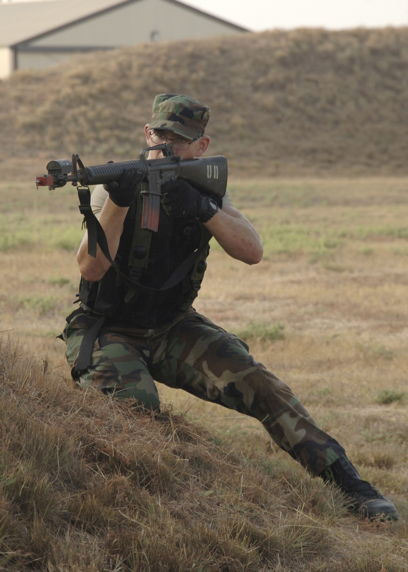 Airman 1st Class Phillip Rogers, 39th Maintenance Squadron, takes cover behind a hill while firing at opposing Airmen during an Air Expeditionary Force exercise Aug. 31. More than 45 Airmen, in AEF buckets 9/10, from several different squadrons participated and are preparing for their upcoming deployments.  (U.S. Air Force photo by Senior Airman Tiffany Colburn)(RELEASED)