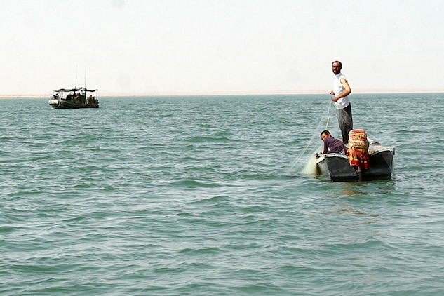 HADITHA DAM, Iraq, (Sept. 16, 2007) – Iraqi fisherman pull in their nets after being warned by sailors with Riverine Squadron 1, Riverine Group 1, Navy Expeditionary Combat Command, in support of Regimental Combat Team 2, about the new temporary 24-hour curfew on the Euphrates River near the dam. The regiment declared the temporary curfew on the waterway to stem the suspected increase of enemy activity on the river during the Muslim holiday of Ramadan. Official Marine Corps Photo By Cpl. Ryan C. Heiser.