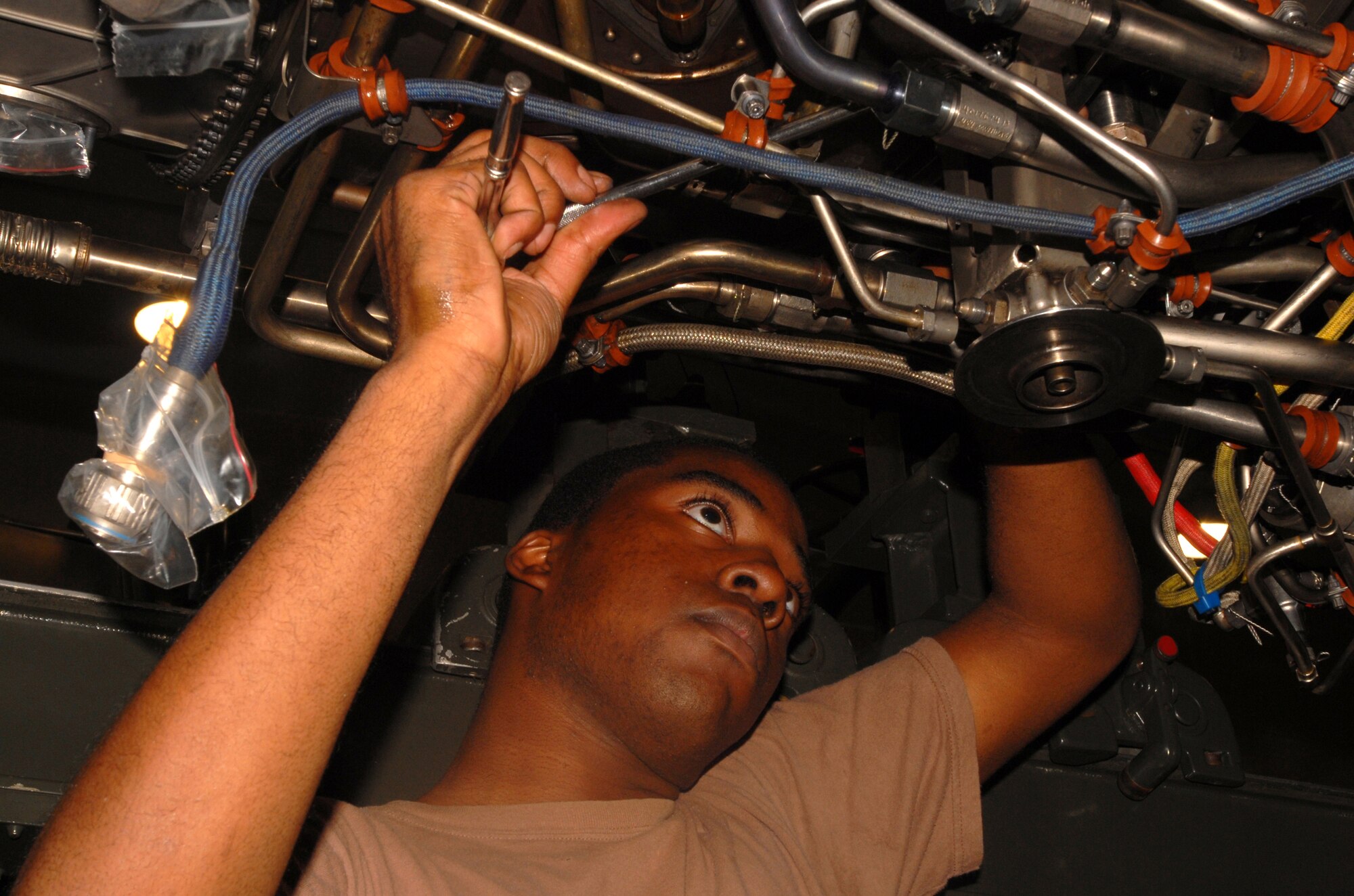 Airman 1st Class Christopher Mason installs a rear fuel drain bracket on an F-15C  F100-PW-220E jet engine at Kadena Air Base Sept. 11, 2007.  Airman Mason works in the aerospace propulsion flight in the 18th Component Maintenance Squadron.  (U.S. Air Force photo/Airman 1st Class Ryan Ivacic)