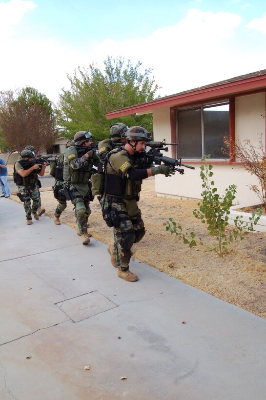 Kern County Sheriff's Department's Specialized Weapons and Tactics team, otherwise known as SWAT, prepares to enter a house during their training here Aug. 30. The base opened a vacant section of the Mesquite Meadows housing area for the SWAT team's training. (Photo by Airman 1st Class Julius Delos Reyes)