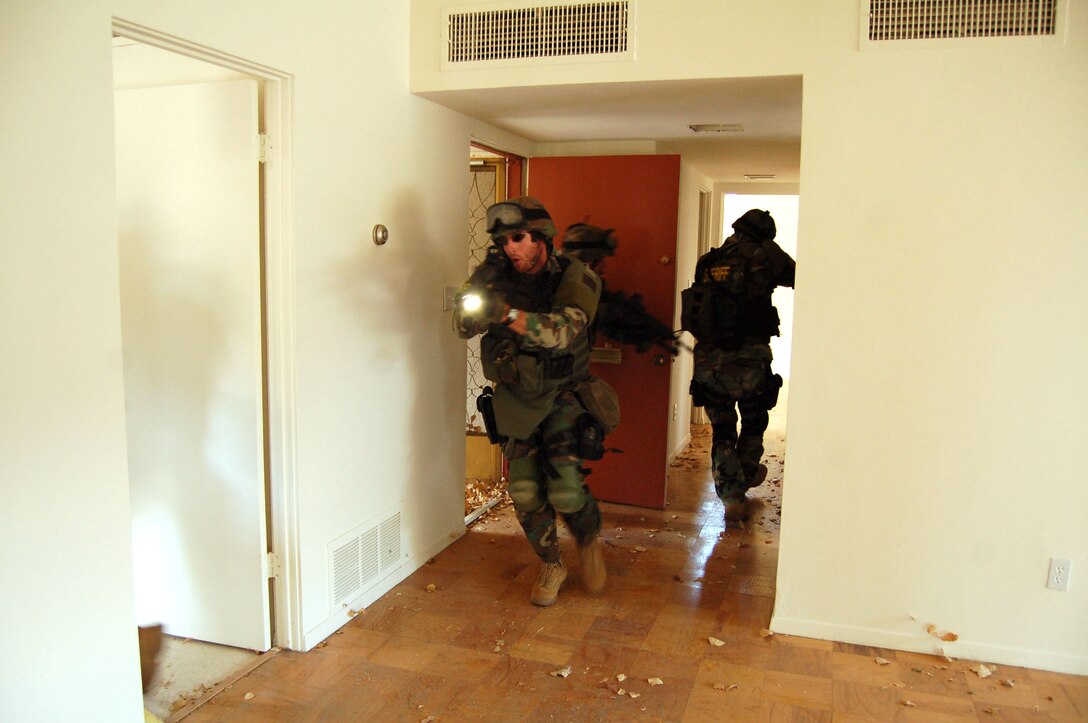Members of the Kern County Sheriff's Department Specialized Weapons and Tactics team practice an entry exercise during their training here Aug. 30. The SWAT team also practiced using their gas masks and night vision goggles. (Photo by Airman 1st Class Julius Delos Reyes)