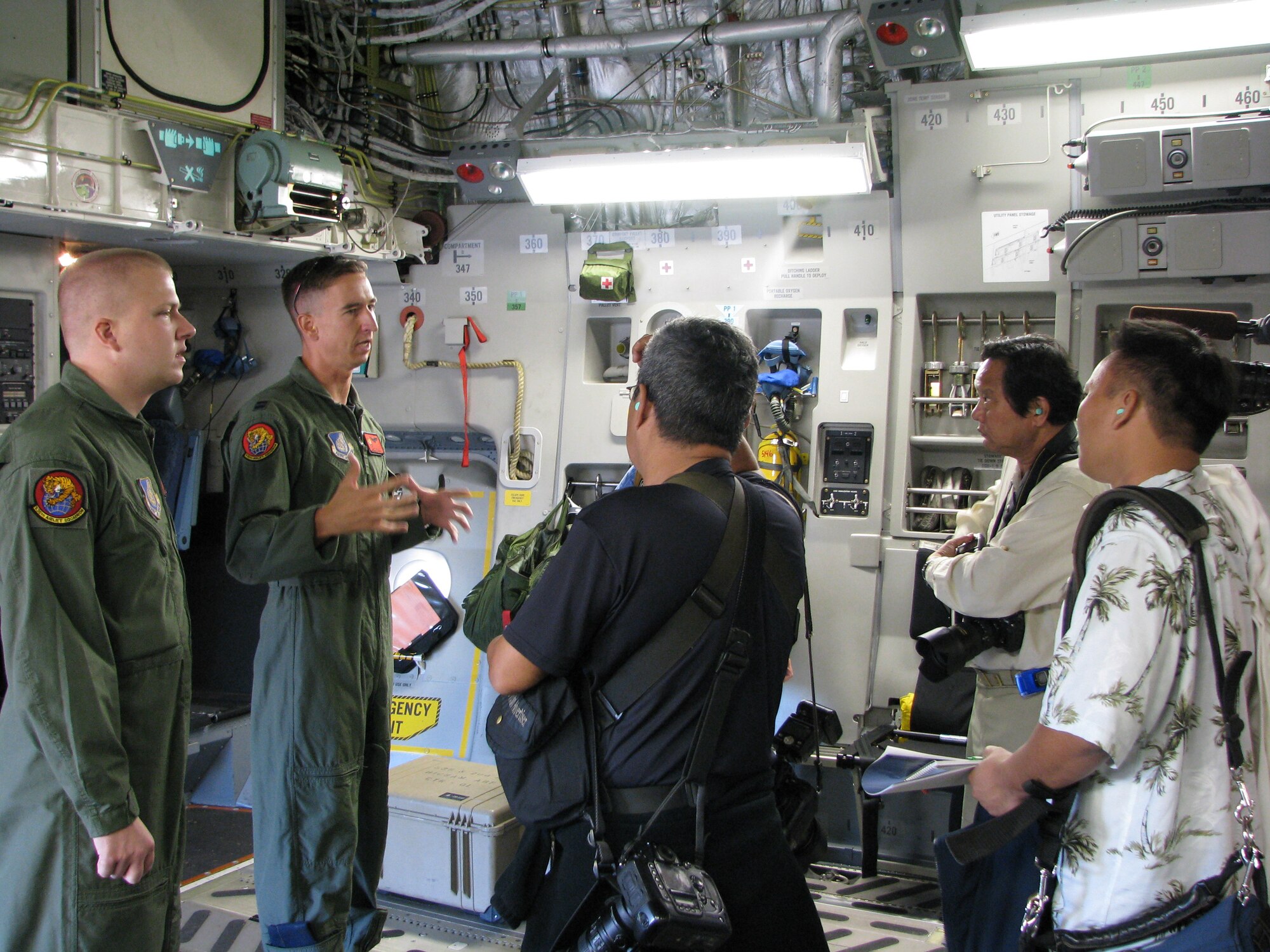 Capt. Jake Wilcox and Senior Airman Todd Tichawa from the 535th Airlift Squadron provide a safety briefing to the local media before going on a two hour C-17 Globemaster III orientation flight.  Flight was designed to show the relevance of these aircraft in Hawaii and showcase aircraft capabilities.