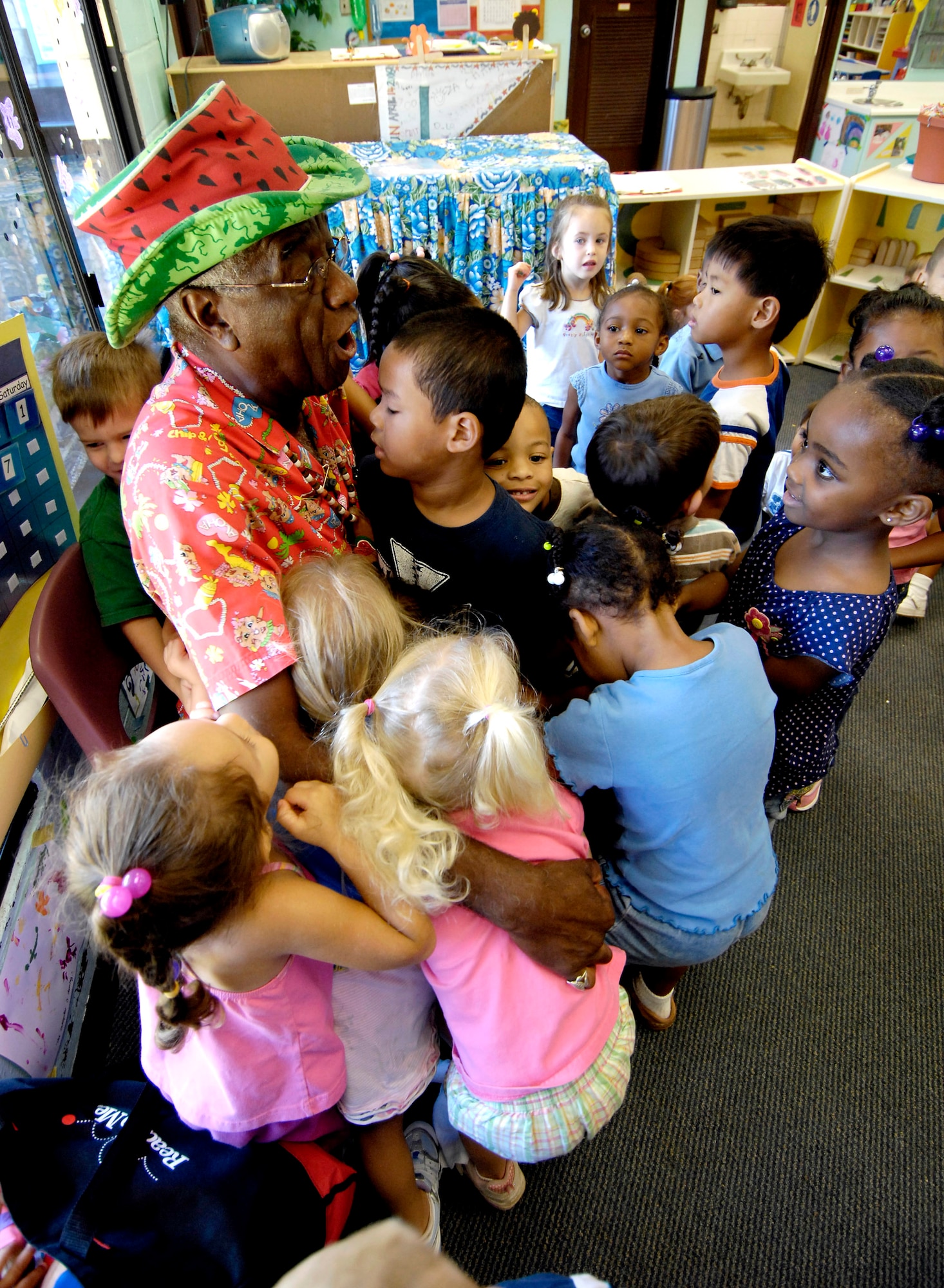 Wally Amos receives hugs from children at the Child Development Center after reading to them Sept. 10 at Hickam Air Force Base, Hawaii. Mr. Amos is an actor, writer and original entrepreneur behind the Famous Amos cookie brand. He is an advocate of literacy and early childhood development, and served in the Air Force four years. He read to children as part of Air Force week Honolulu. (U.S. Air Force photo/Tech. Sgt. Shane A. Cuomo) 
