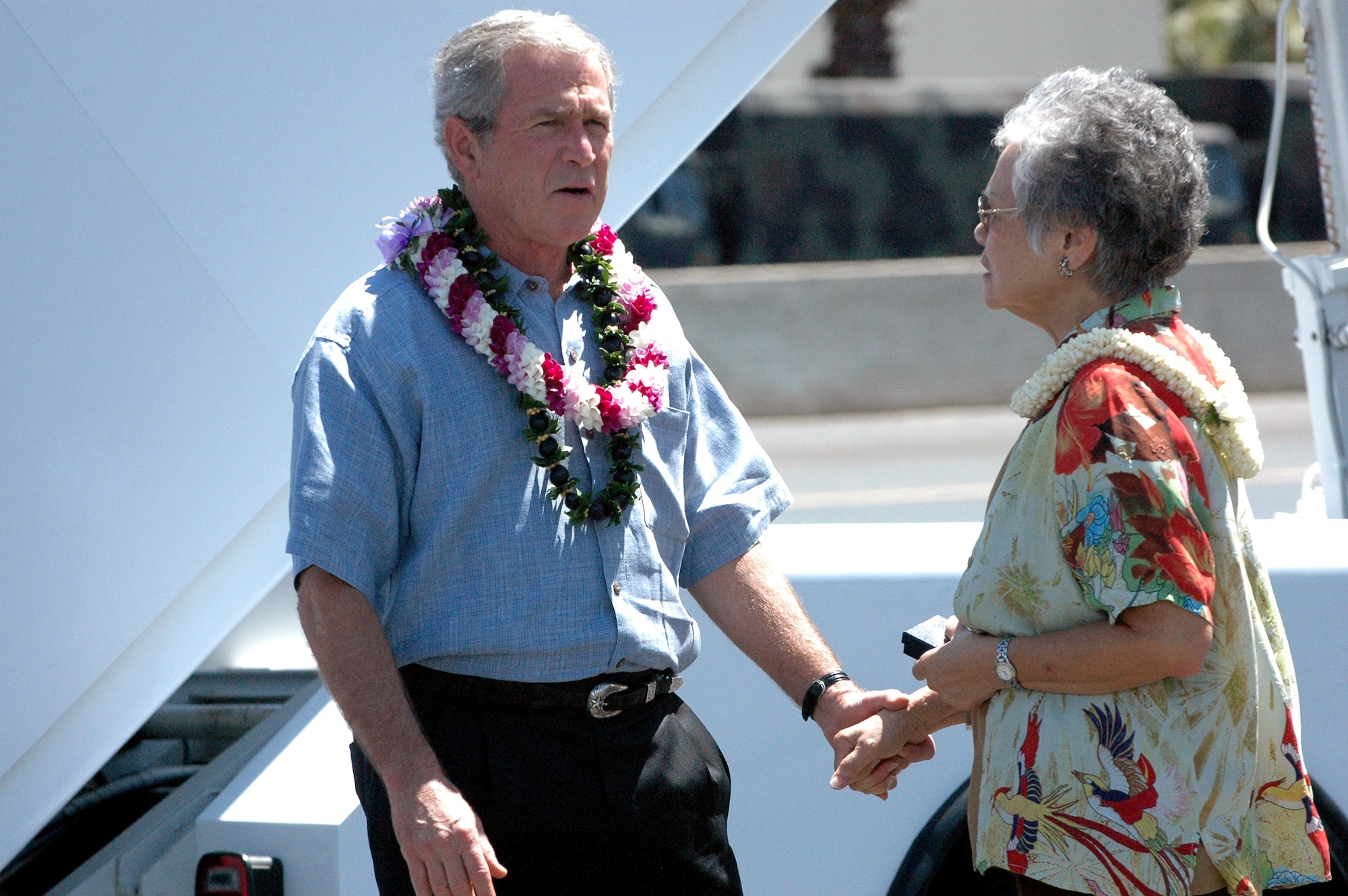 President George W. Bush meets with Caroline Tom to present her a volunteer service pin, recognizing her for 15 years of volunteering her time, Sept. 8 at Hickam Air Force Base, Hawaii. The president also met with 33 wounded servicemembers and their families. (U.S. Air Force photo/2nd Lt. Melanie McLean)