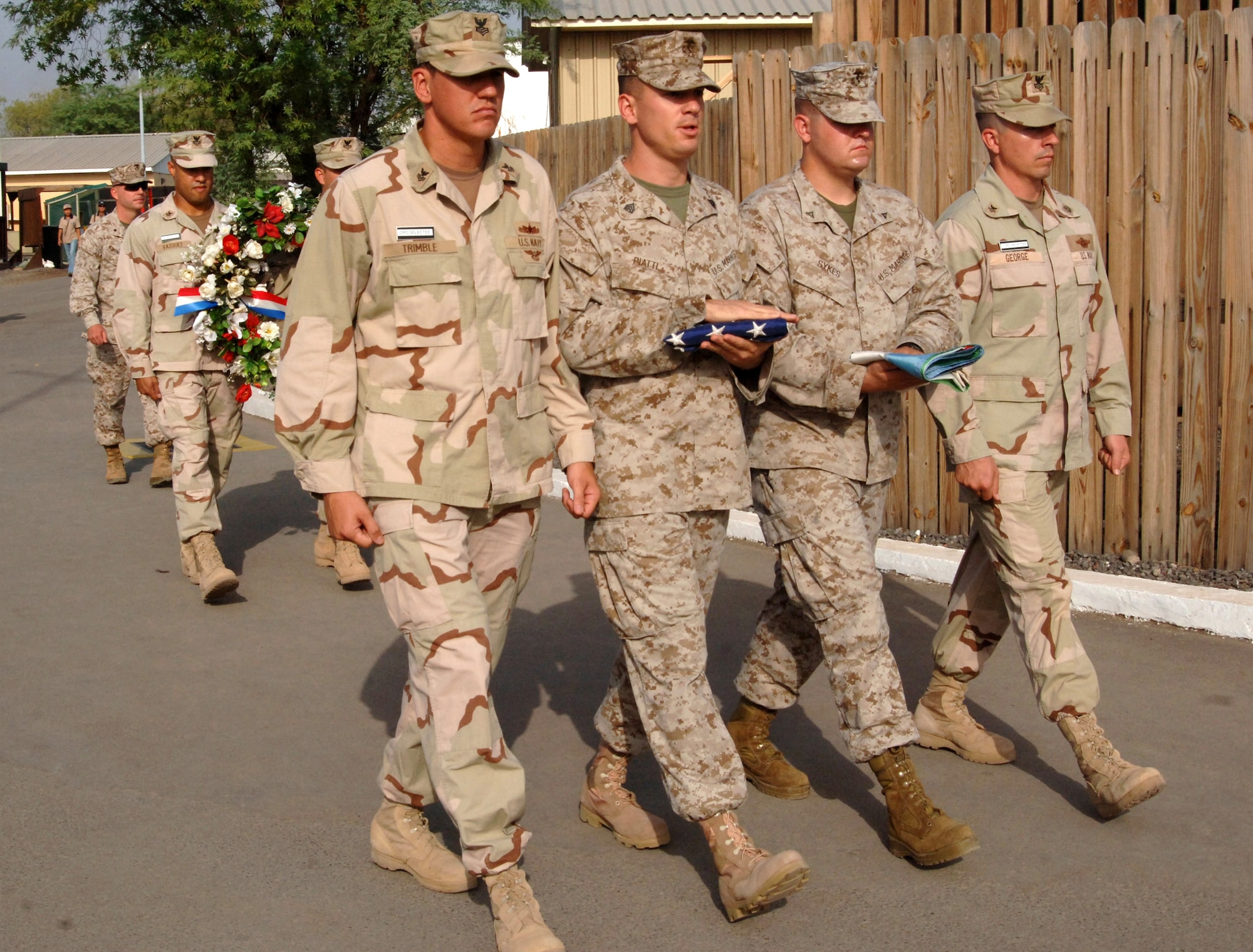 Members of the color guard march to the flagpole as Navy petty officers carry a wreath in remembrance of the sixth anniversary of Sept. 11 at Camp Lemonier, Djibouti. The wreath presentation was one of the Sept. 11, 2001, remembrance events sponsored by Combined Joint Task Force-Horn of Africa 2008 Navy chief selectees. (U.S. Navy photo/Petty Officer 2nd Class Regina L. Brown)

