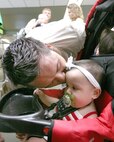 Returning 37th Security Forces Squadron member Staff Sgt. Jared Norwood gives his daughter Tessa a long-awaited hello kiss at the San Antonio International Airport. Sergeant Norwood was one of 12 squad members who returned to Lackland Air Force Base, Texas, Sept. 4, 2007, after spending six months supporting Operation Enduring Freedom. (USAF photo by Robbin Cresswell)