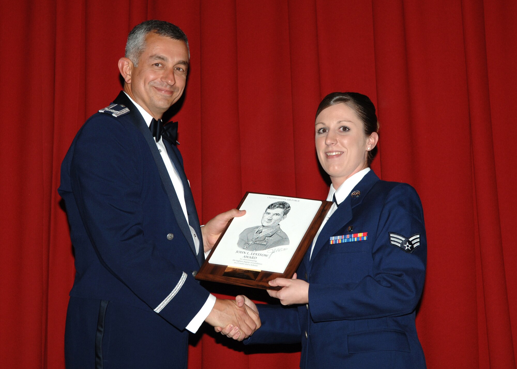 FAIRCHILD AIR FORCE BASE, Wash. – Col. Roger Watkins, 92nd Air Refueling Wing vice commander, presents the John L. Levitow Award to Senior Airman Misty Cole of the 92nd Medical Operations Squadron at her Airman Leadership School graduation Sept. 6. The Levitow Award is highest honor in Enlisted Professional Military education, presented to the class's top student. (U.S. Air Force photo / Airman 1st Class Jocelyn Ford)