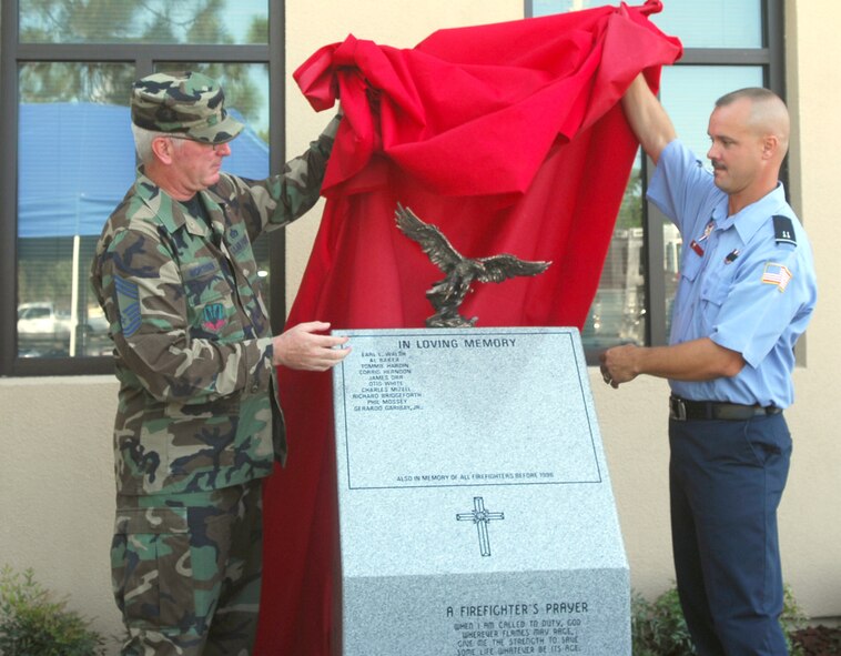 Chief Master Sgt. Eric Mortensen, Moody's fire chief, and Kevin Sullivan, Moody firefighter and crew chief, unveil a monument dedicated to the Moody firefighters who lost their lives in the line of duty during a ceremony Sept. 11. The event was held in honor of firefighters and American citizens who lost their lives during the Sept. 11, 2001, terrorist attacks. (U.S. Air Force photo by Senior Airman Angelita Lawrence)
